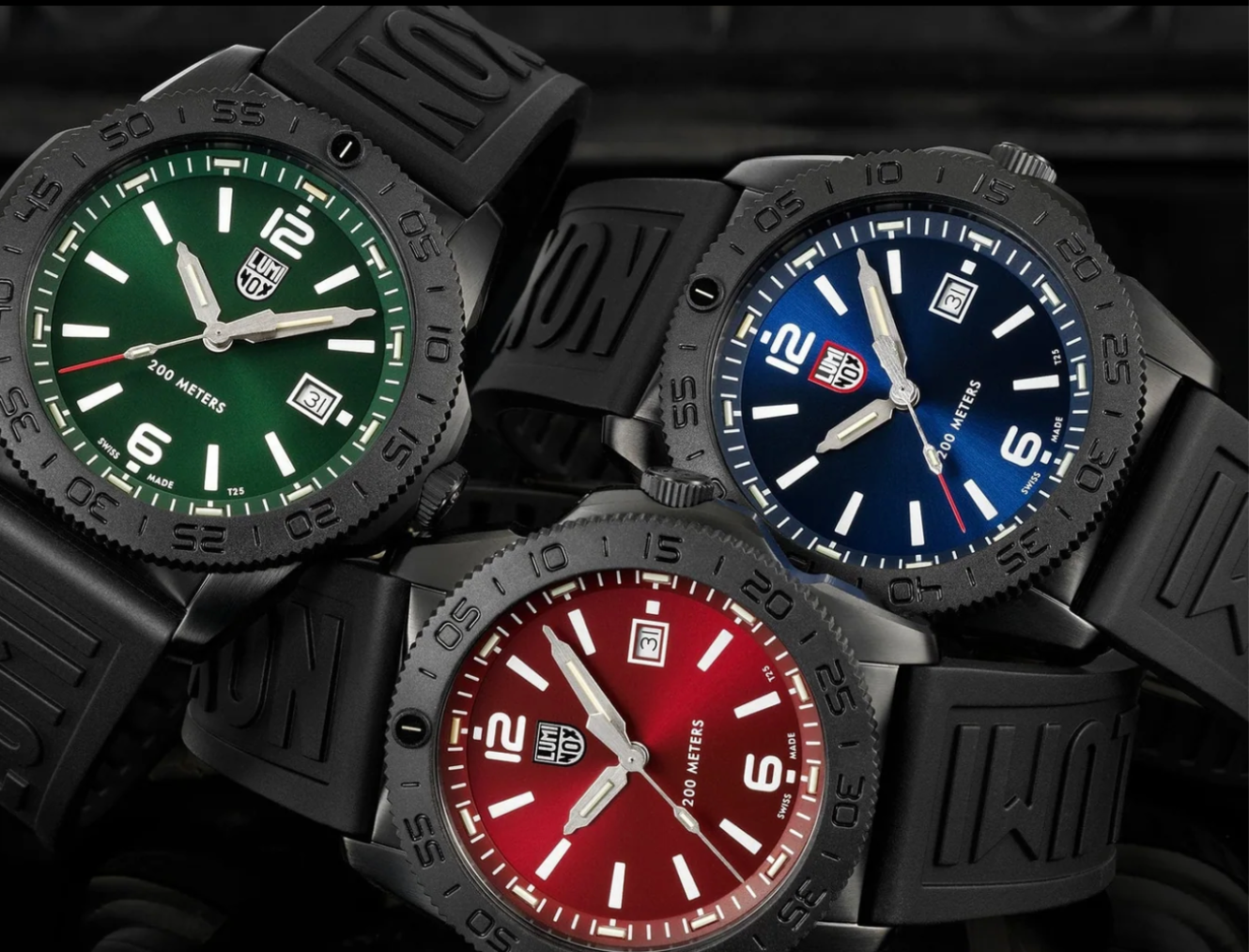 3 black watches in a group, one has green dial, one has red, one has blue. 