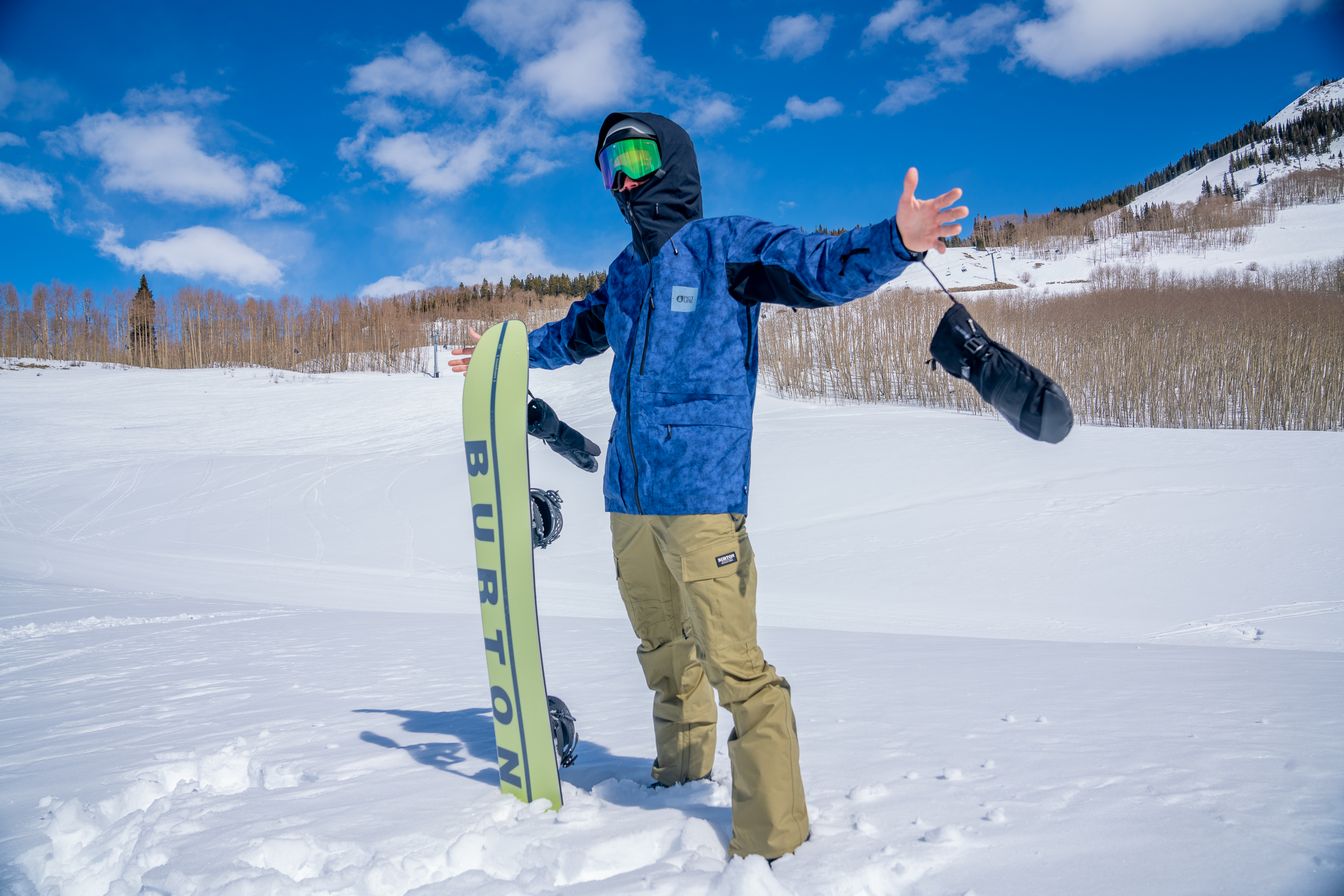 Snowboarder poses with jacket at ski resort