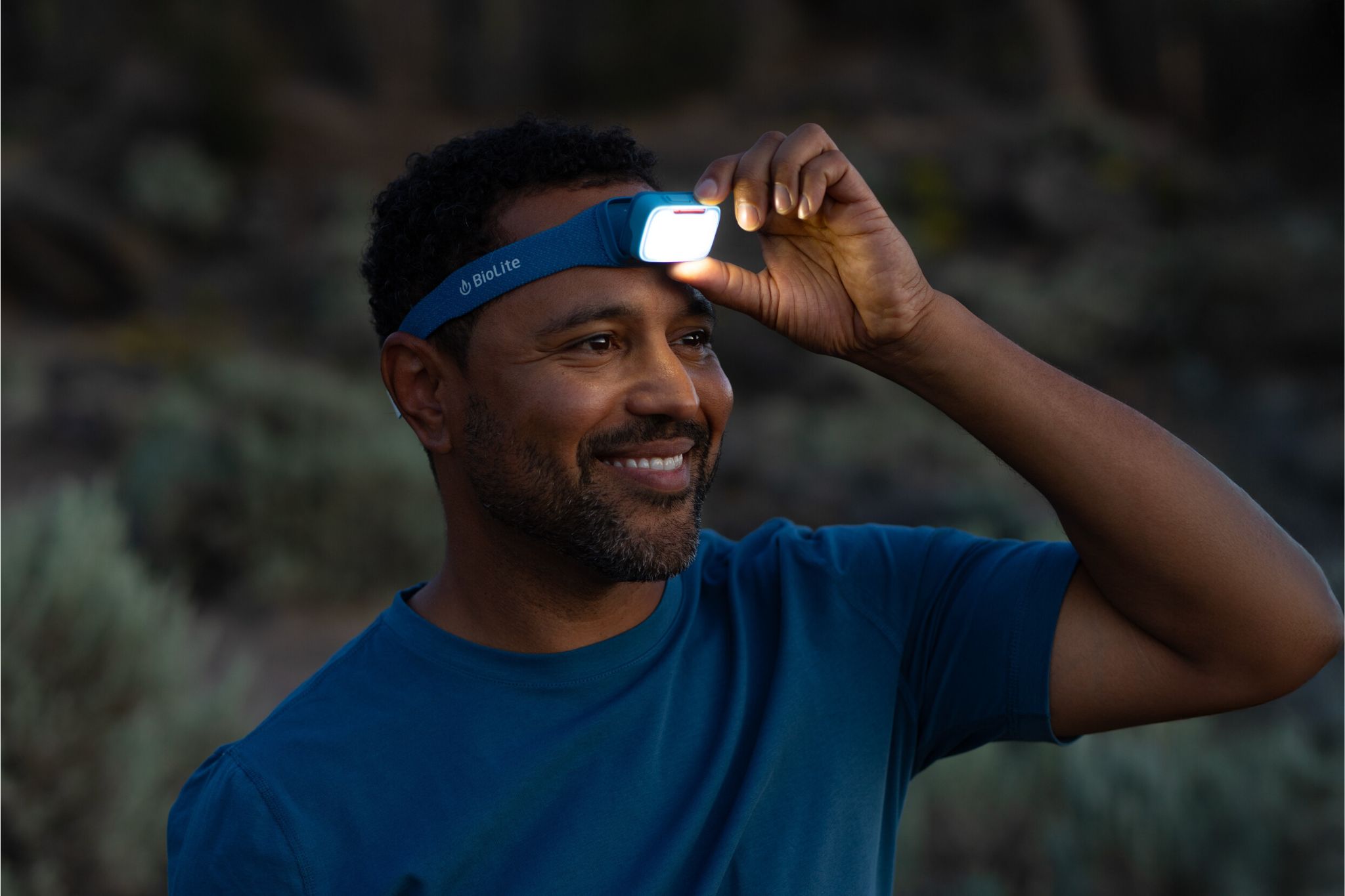 Persons adjusts blue headlamp that is turned on