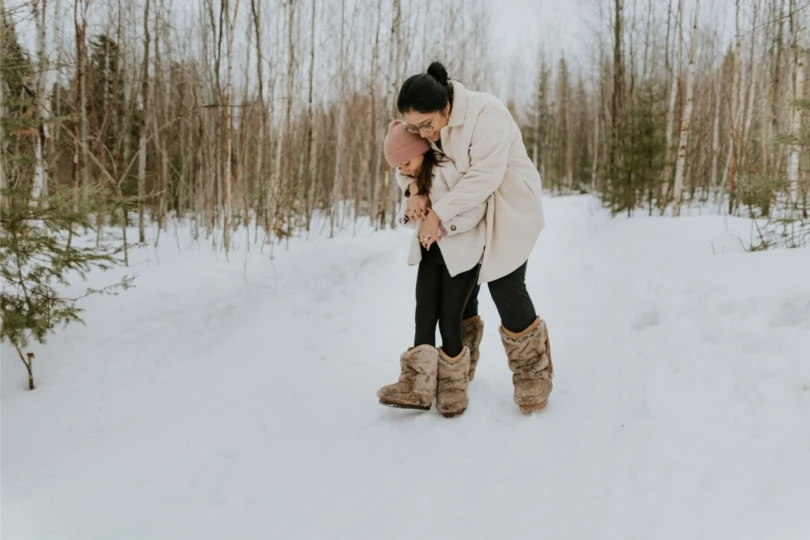 Mom and daughter in snow with furry boots