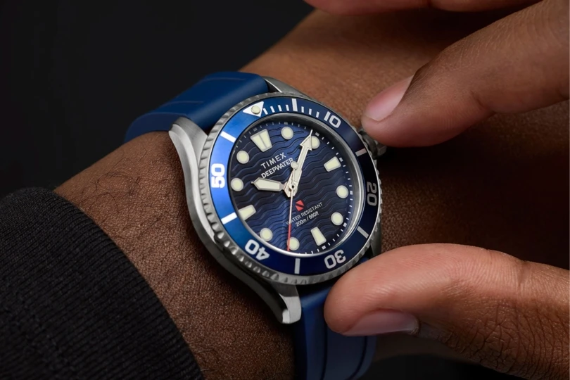 Close up shot of person adjusting blue timex watch on their wrist