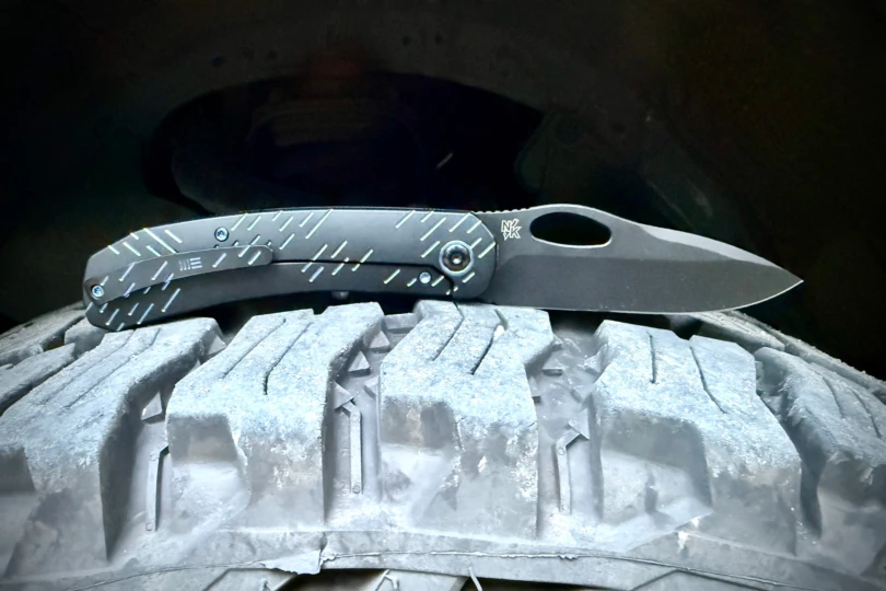 WE Knife Inmate resting on a rugged tire tread