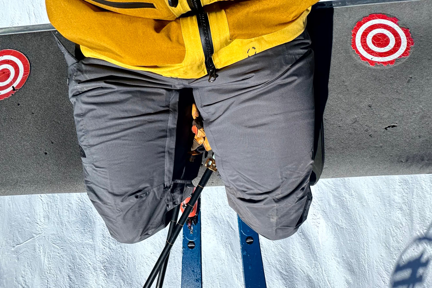 Person wearing gray The Nroth Face Freedom pants sitting on a ski lift