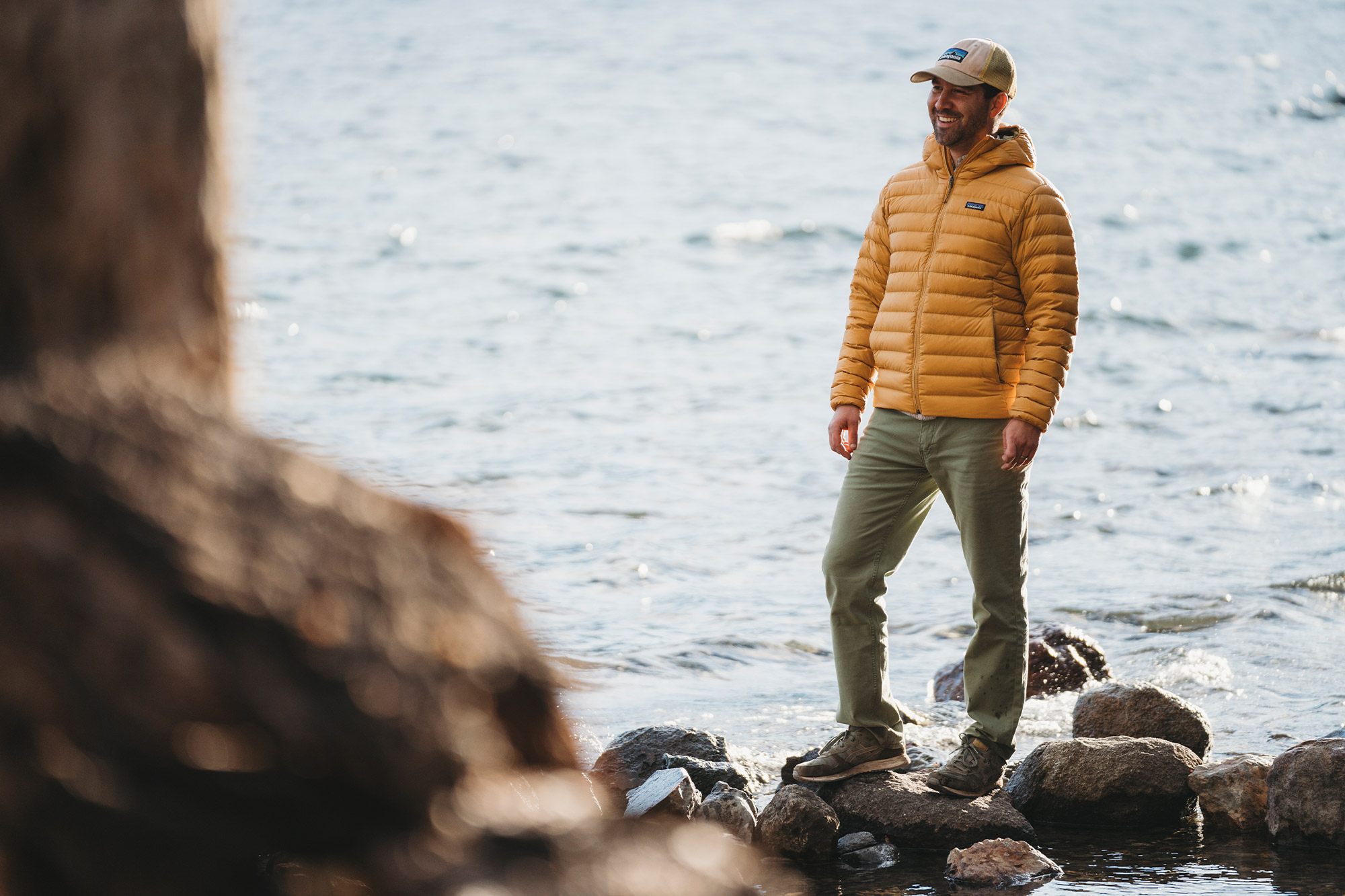 Patagonia Down Sweater Hoody in yellow by the water