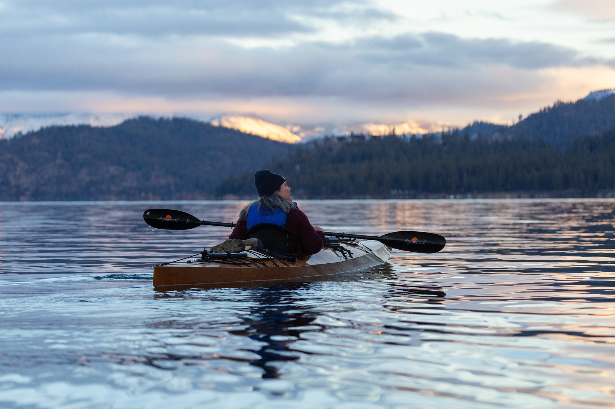 A kayaker floats on a calm lake at sunset in Nevada.