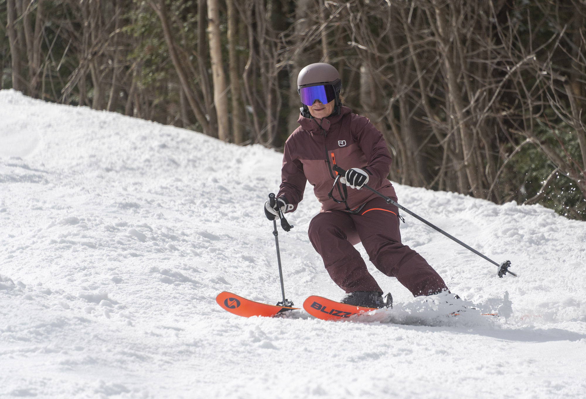 A skier in maroon outfit making a turn on Blizzard Black Pearl 88 skis