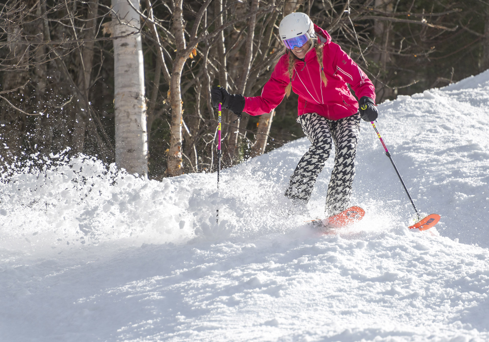 A skier kicking up powder with Blizzard Black Pearl 88 skis on a sunny run
