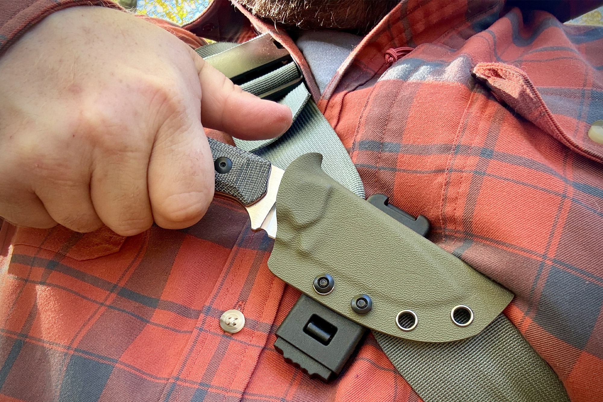 Kizer Beaver Knife carried on a chest strap for quick access