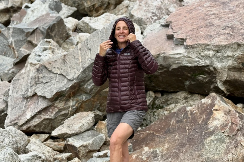 Mountain Hardwear Ghost Whisperer Hoody with hood up and hands adjusting