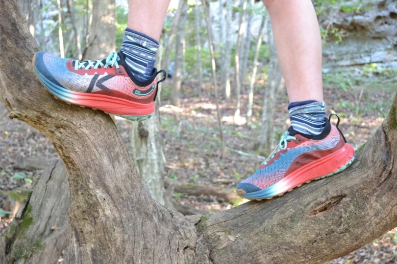 Person stands on tree with running shoes
