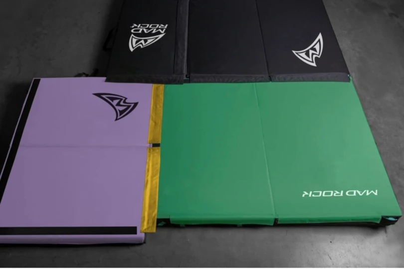 Black, teal, and purple crash pad on the ground