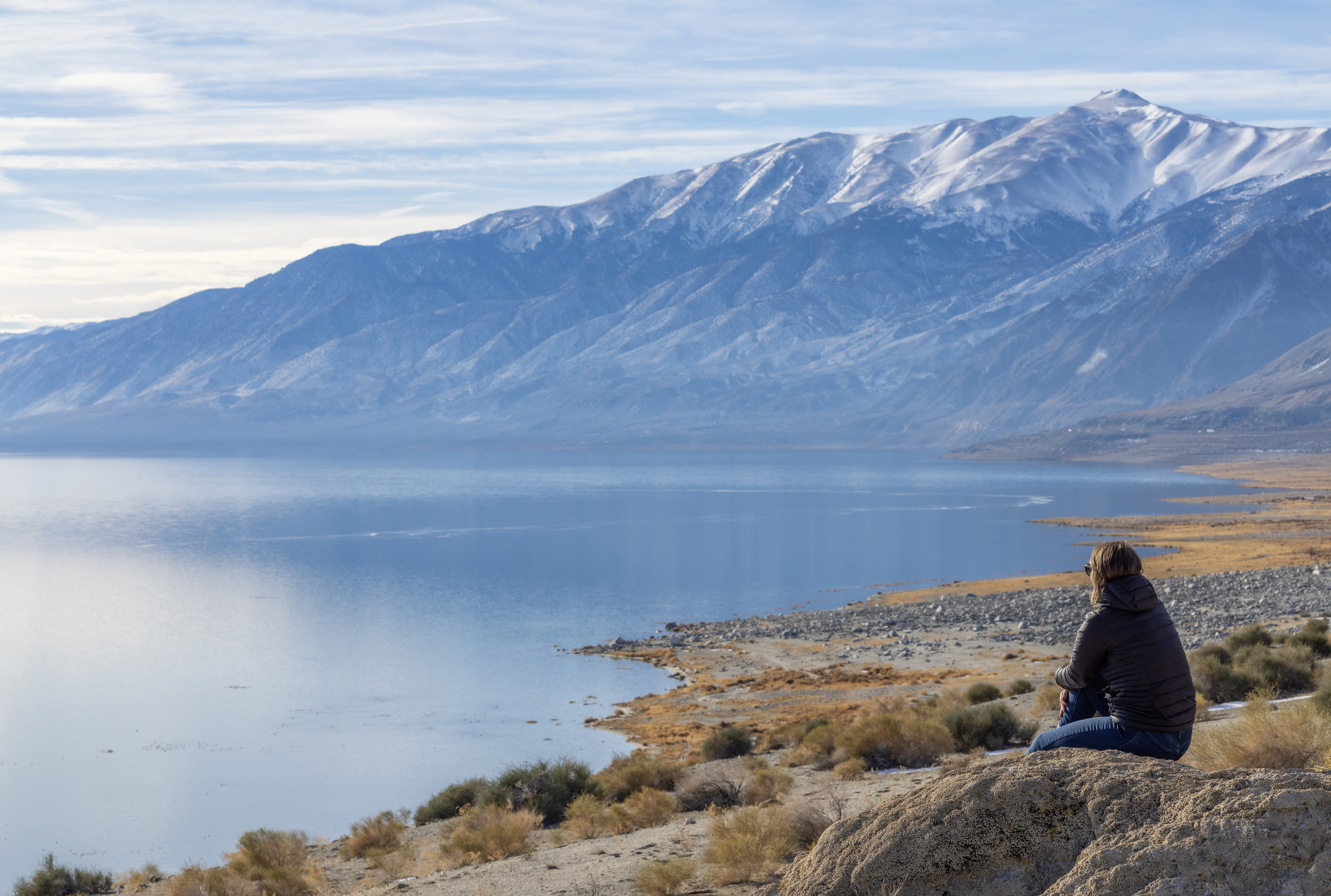 A person sitting on the shores of Walker Lake in the early morning.