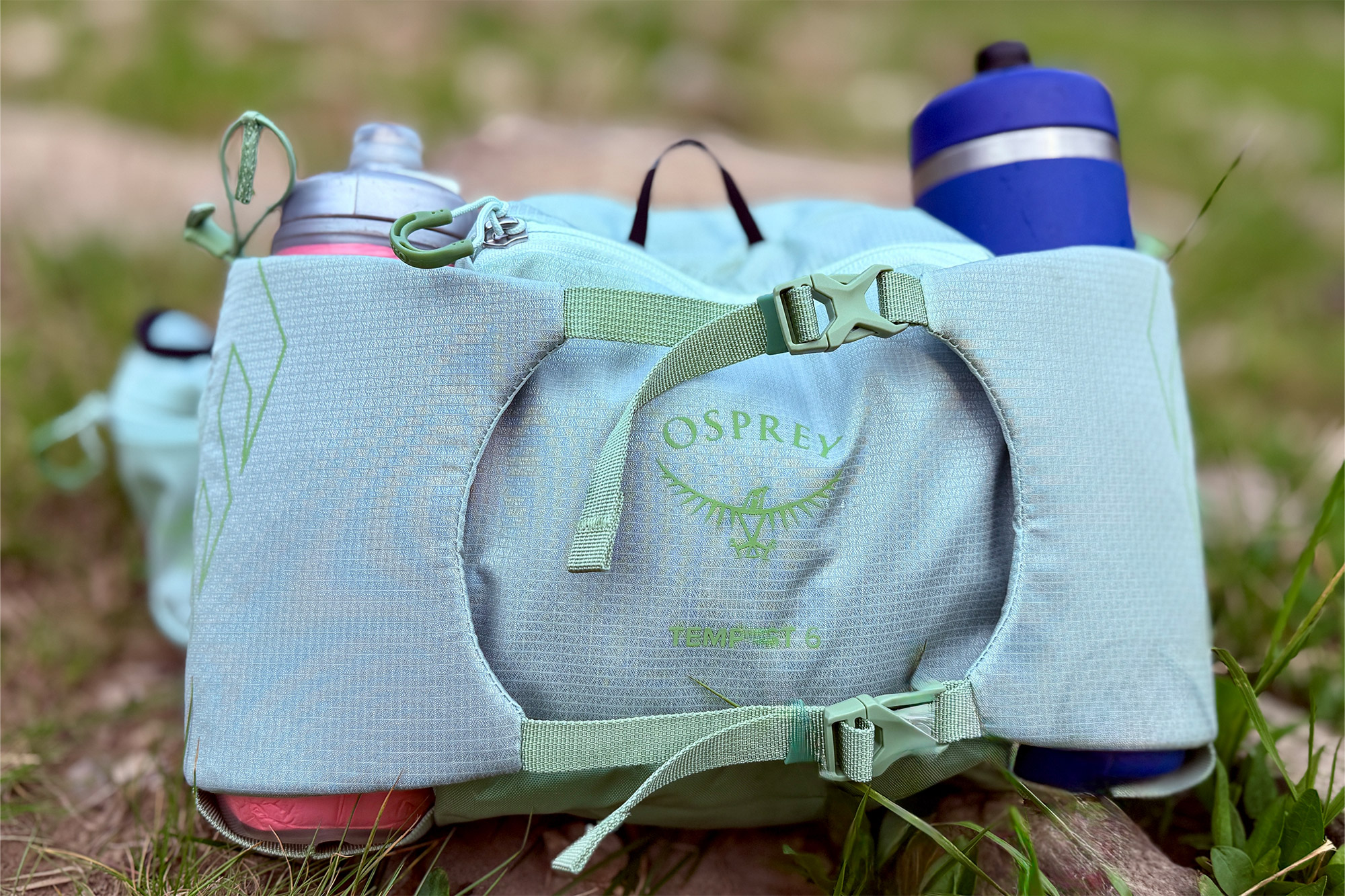 Close-up of the Osprey Tempest 6 Waistpack showing the logo, buckles, and dual water bottle holders