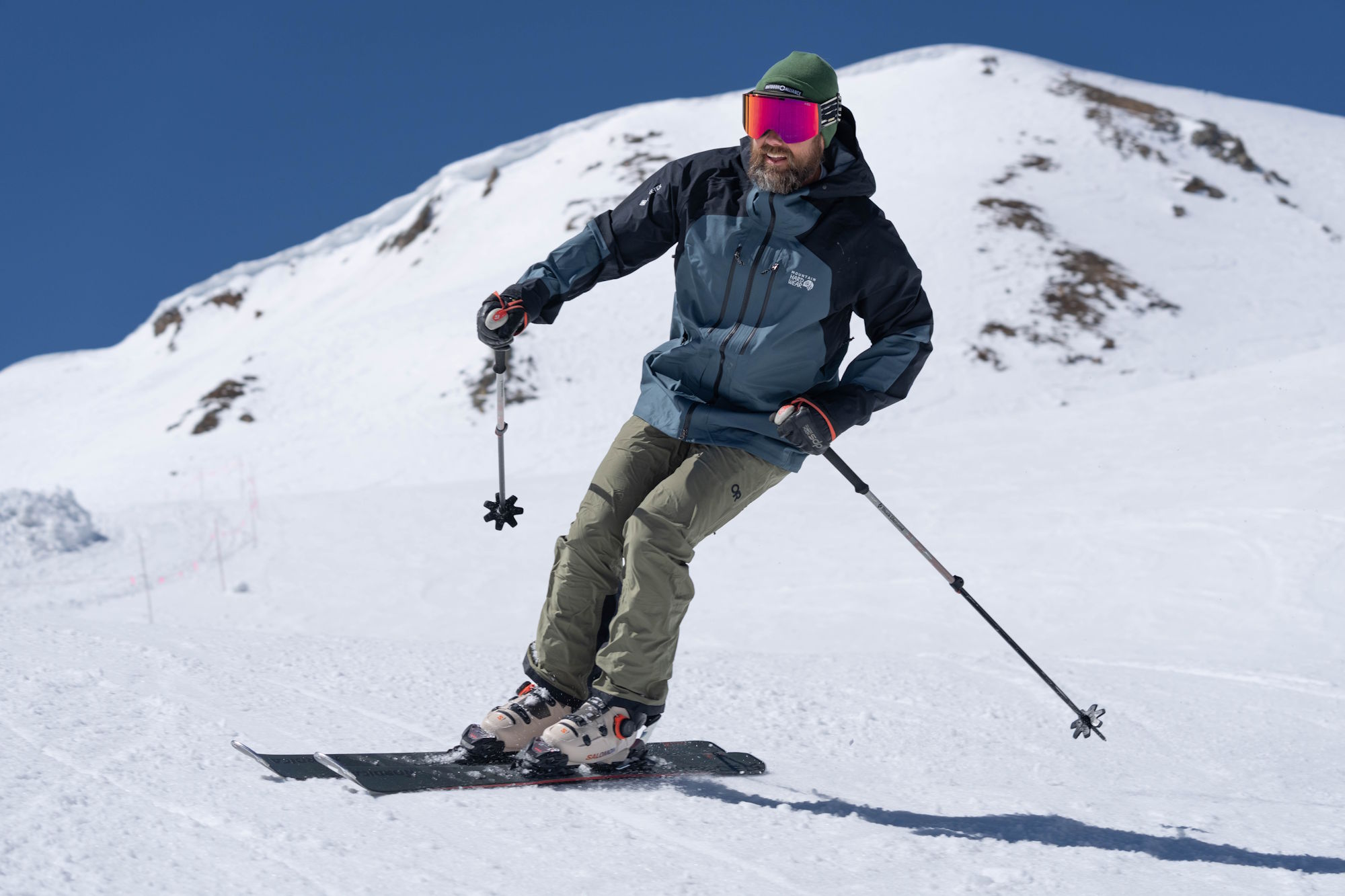 Skier carving down a snowy slope wearing Salomon S/Pro Supra 120 Ski Boots with Dual BOA system.