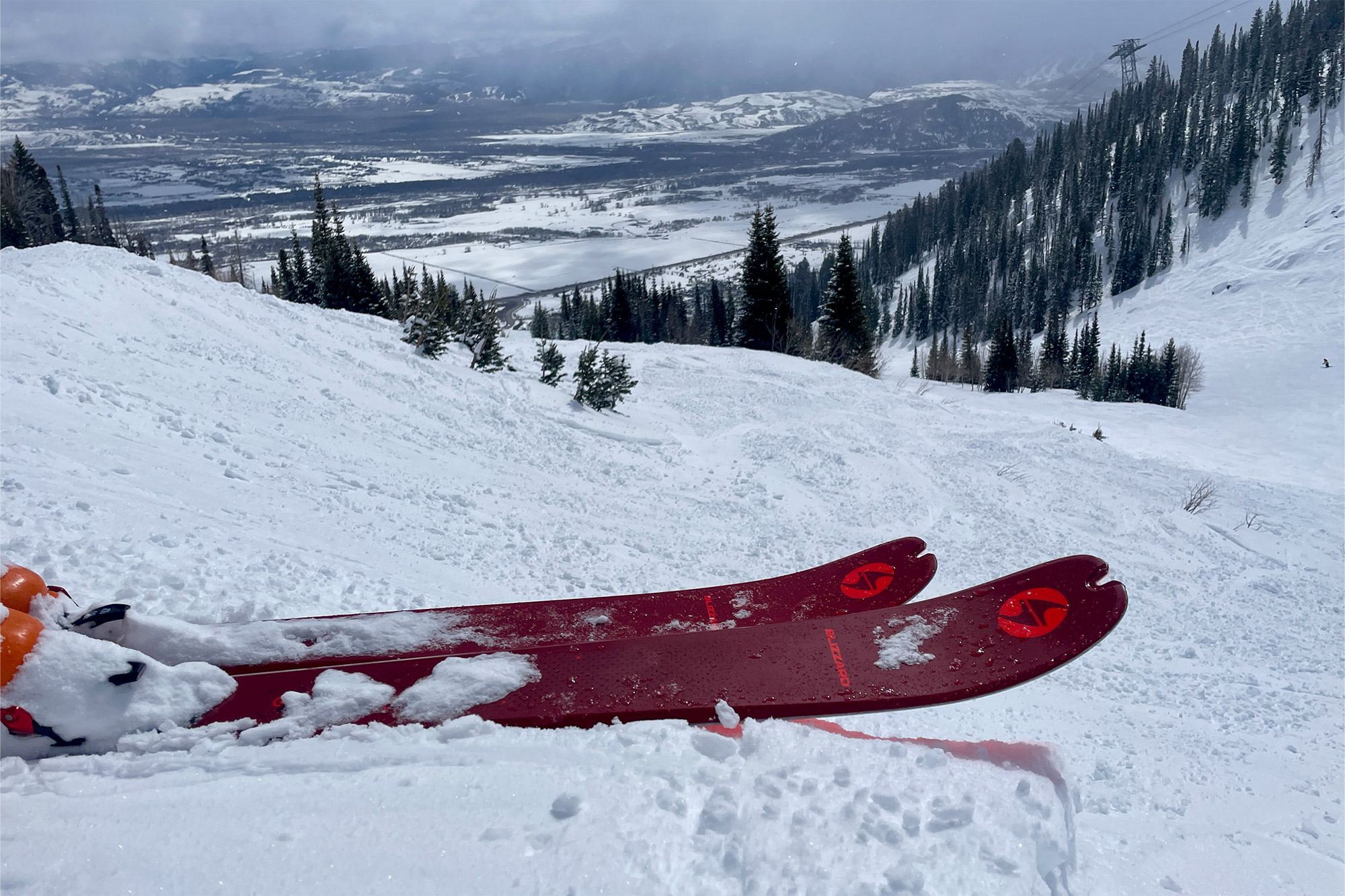 The Blizzard Zero G 96 skis rest on a snowy ridge overlooking a mountain valley