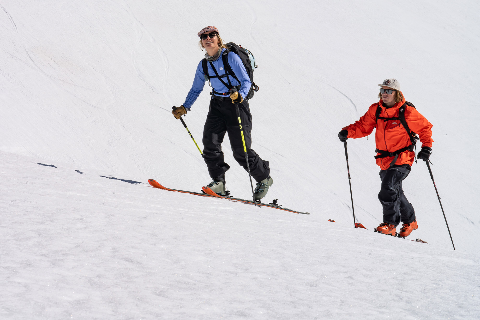 Two skiers ascend a snowy slope using touring gear with Zero G ski