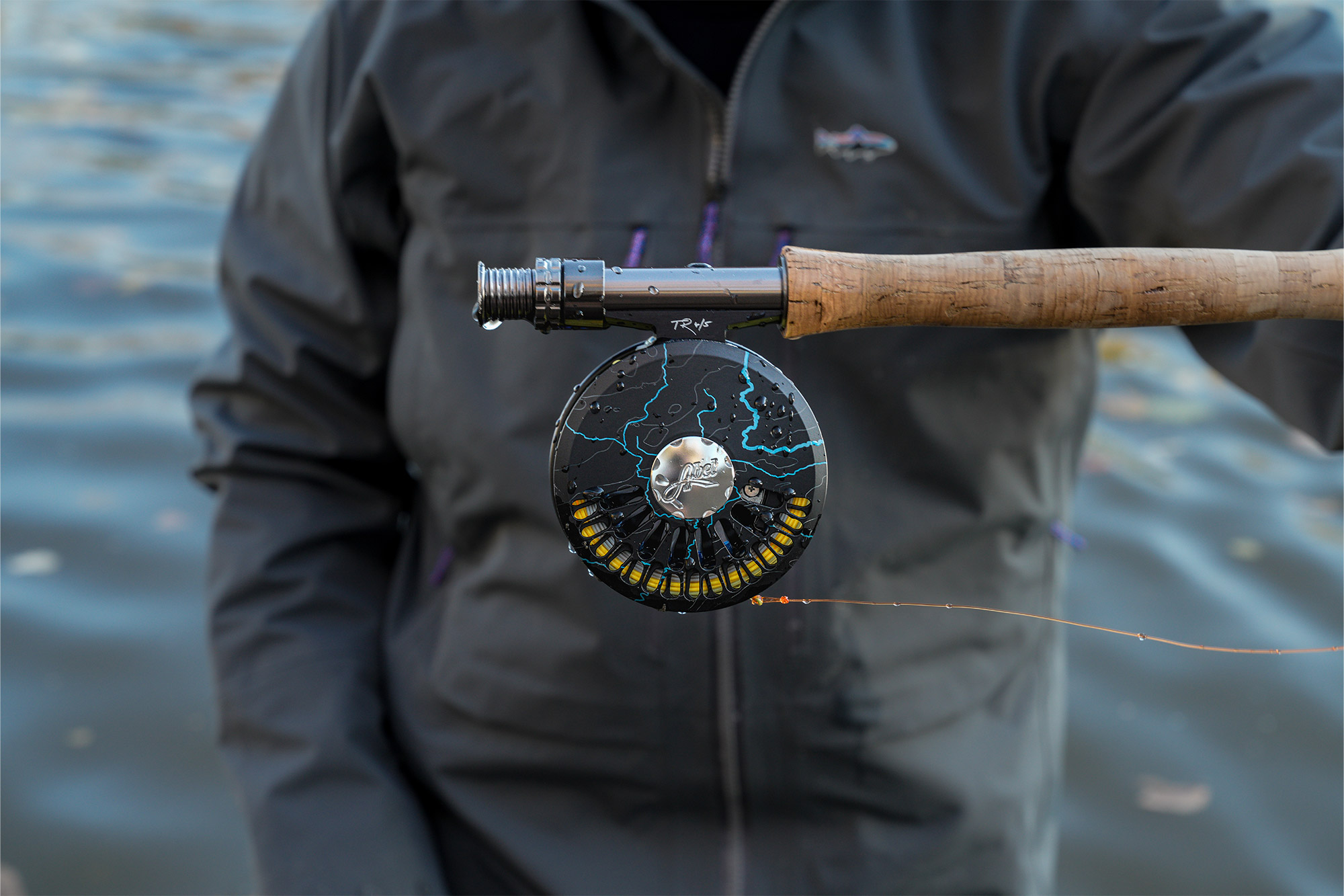 Front view of the custom reel showing blue river pattern details and wet cork handle