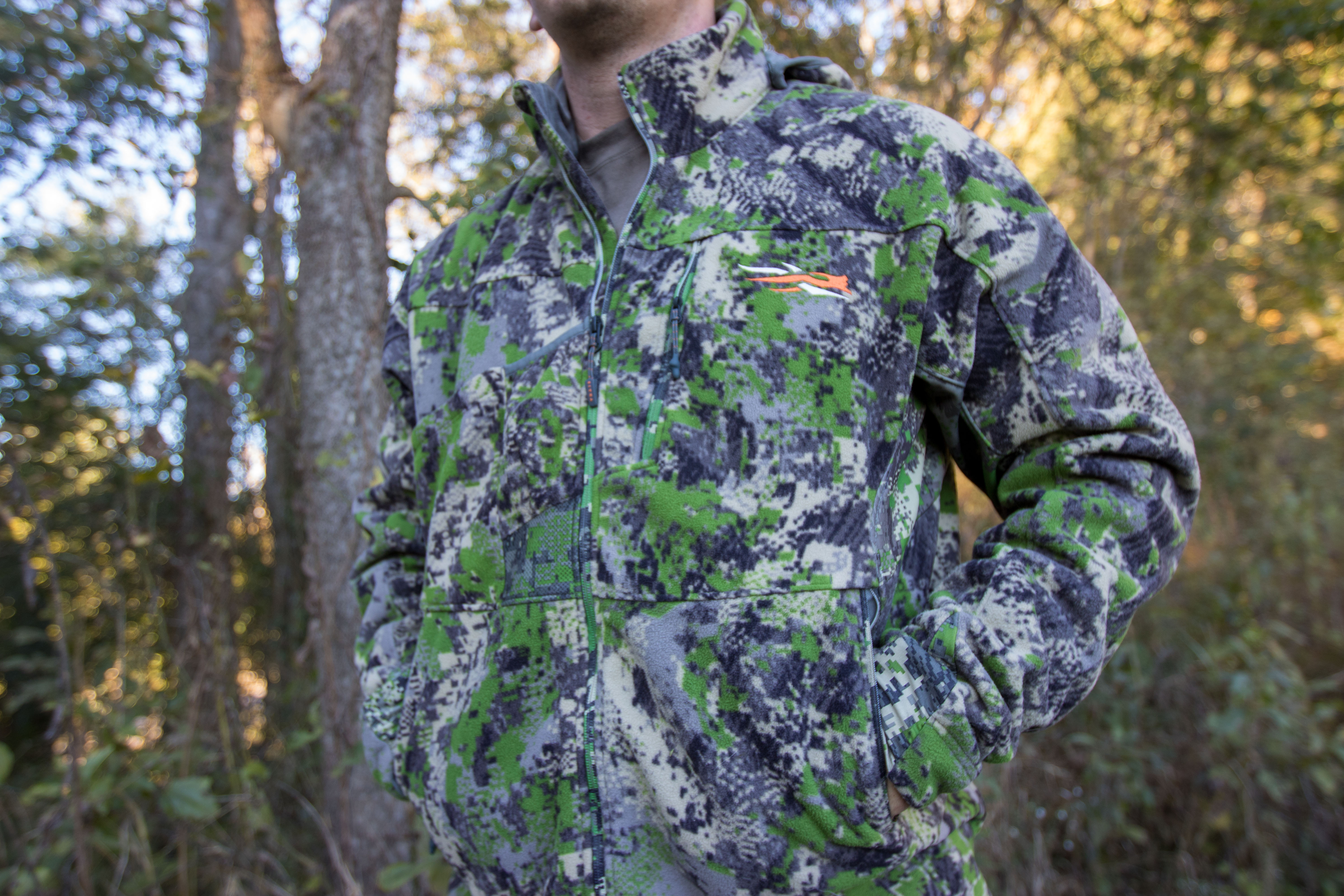 The SITKA Stratus 2.0 Jacket on a hunter in front of a wood line.