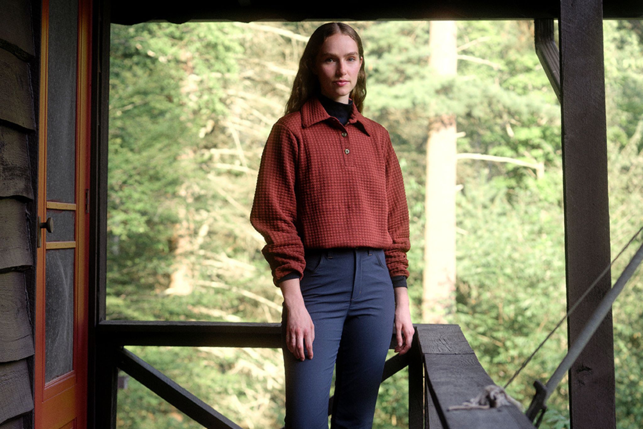 Woman stands outside of cabin