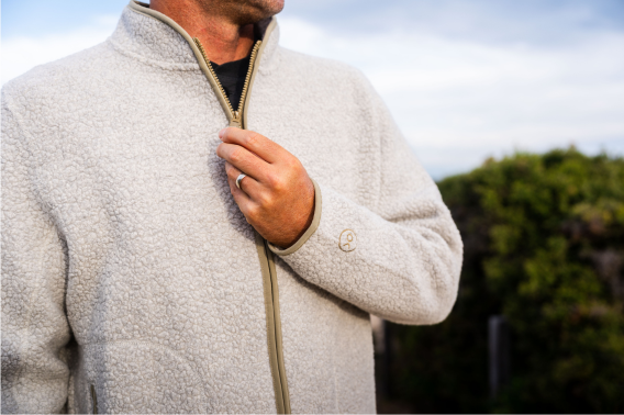 Close up shot of person zipping up gray fleece jacket