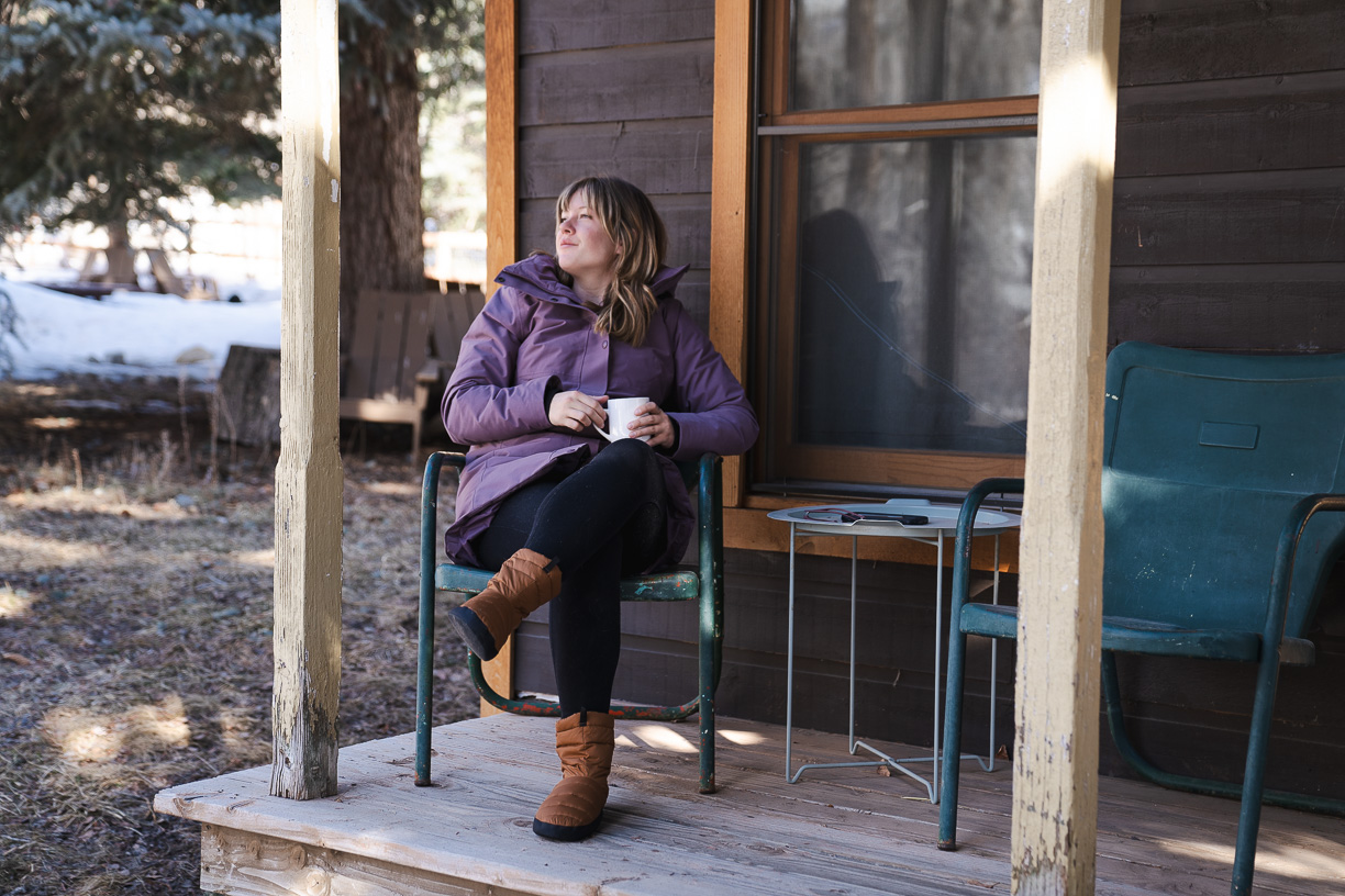 the Marmot Women's Chelsea Coat on a woman sitting on covered porch