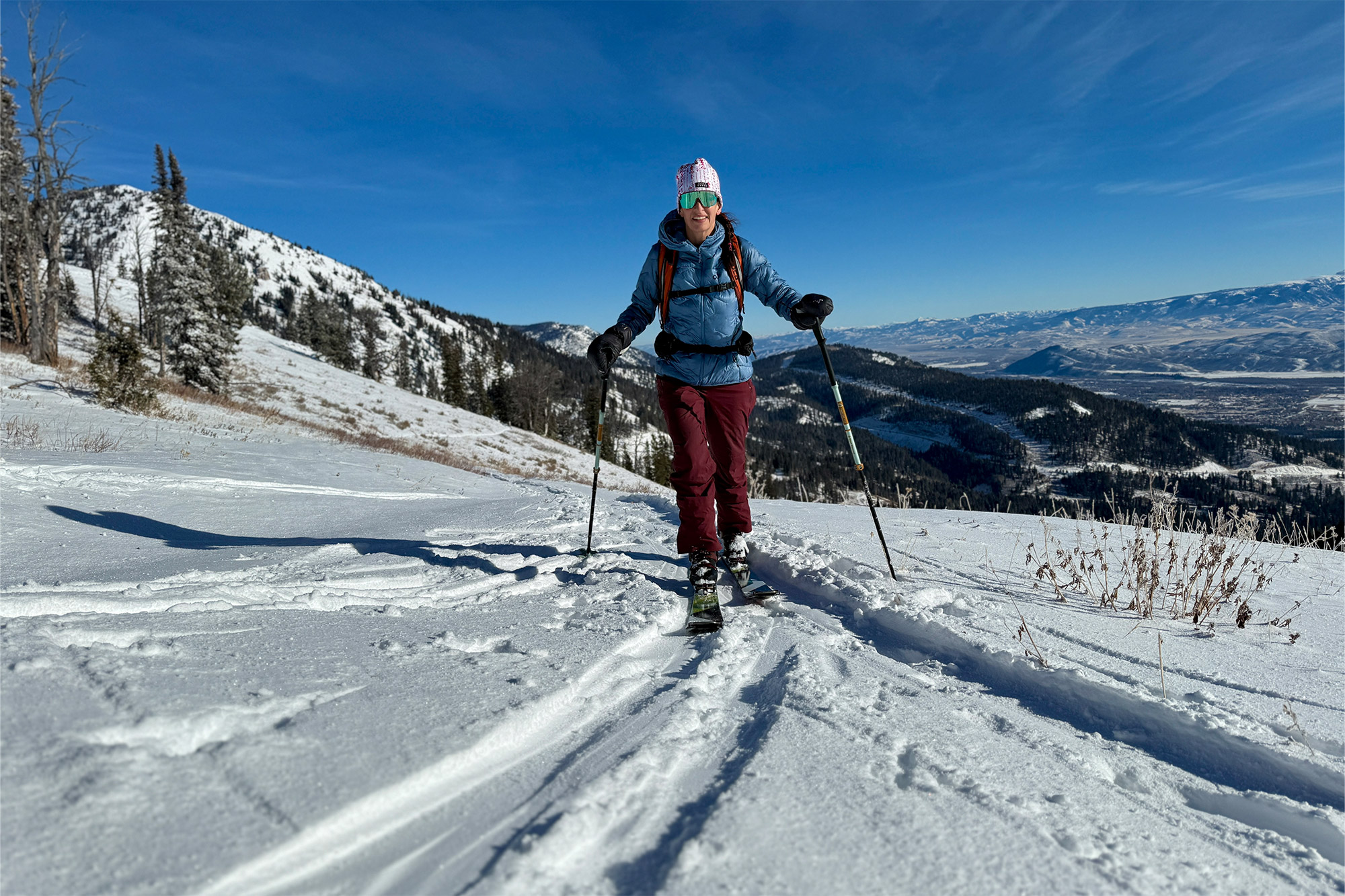 Skinning uphill with winter mountains stretching in the distance