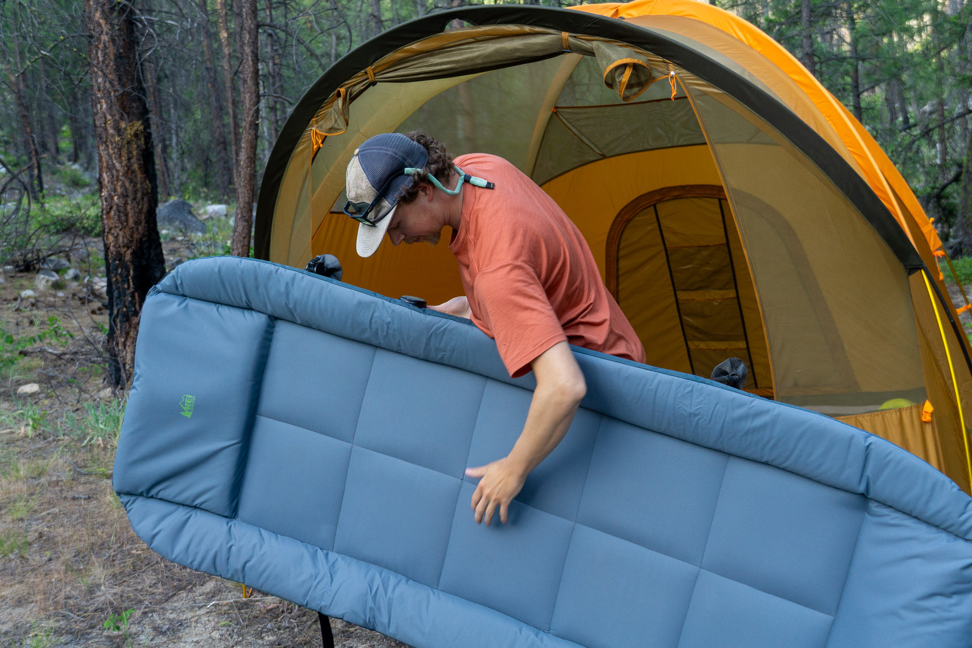 the author carries the wonderland comfort cot into a tent