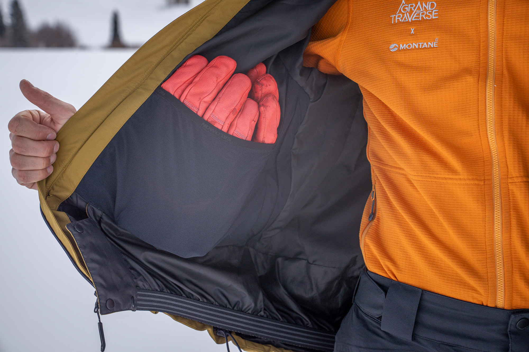 A rider shows the large inside pocket of the Salomon Venom Full Zip Jacket with gloves stored inside