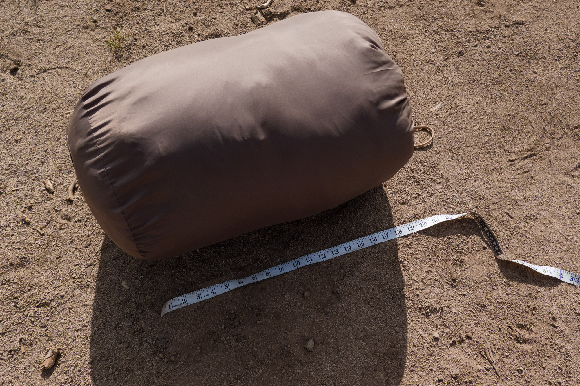 the packed siesta sleeping bag on the ground beside a ruler