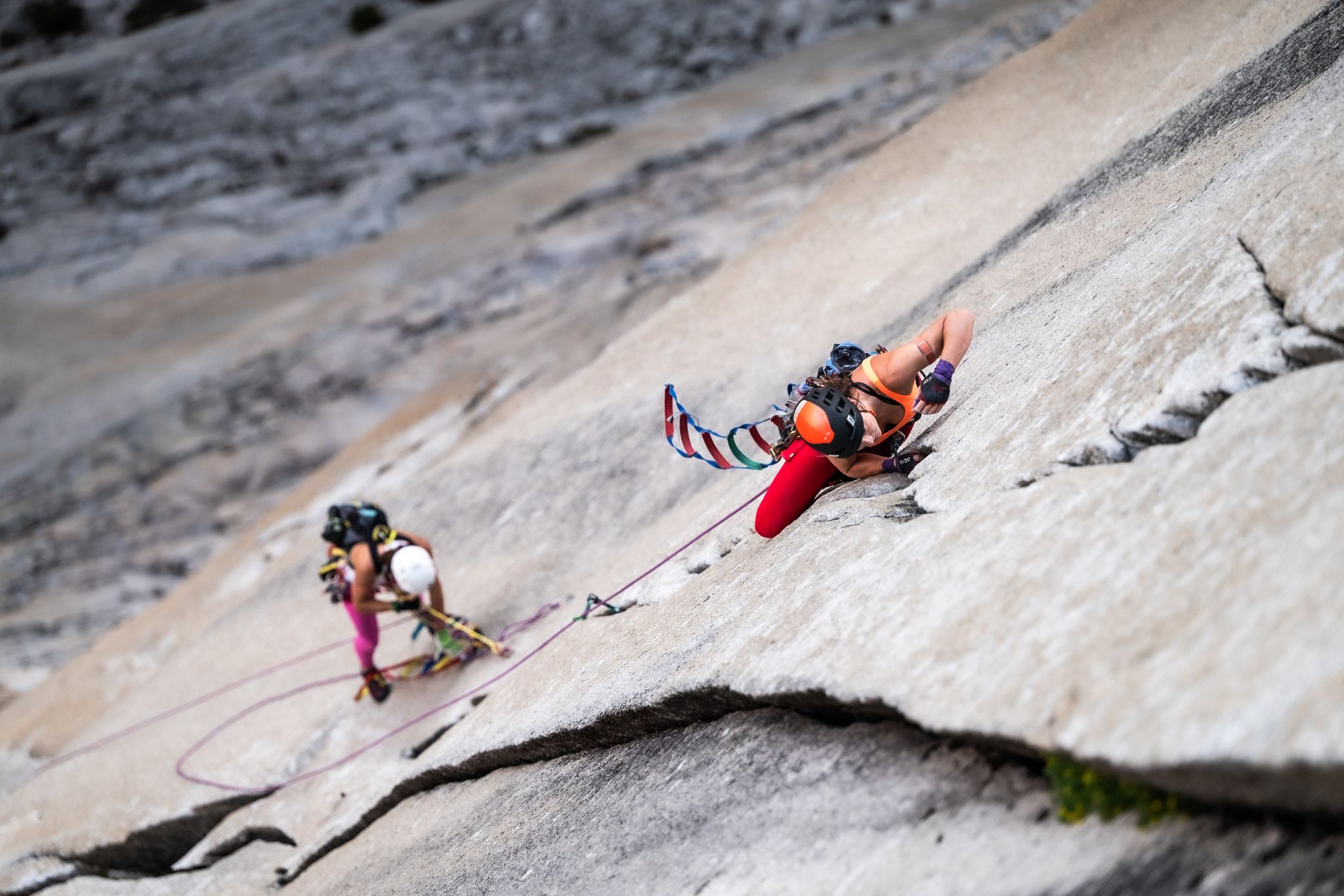 two women climb up wall in Yosemite