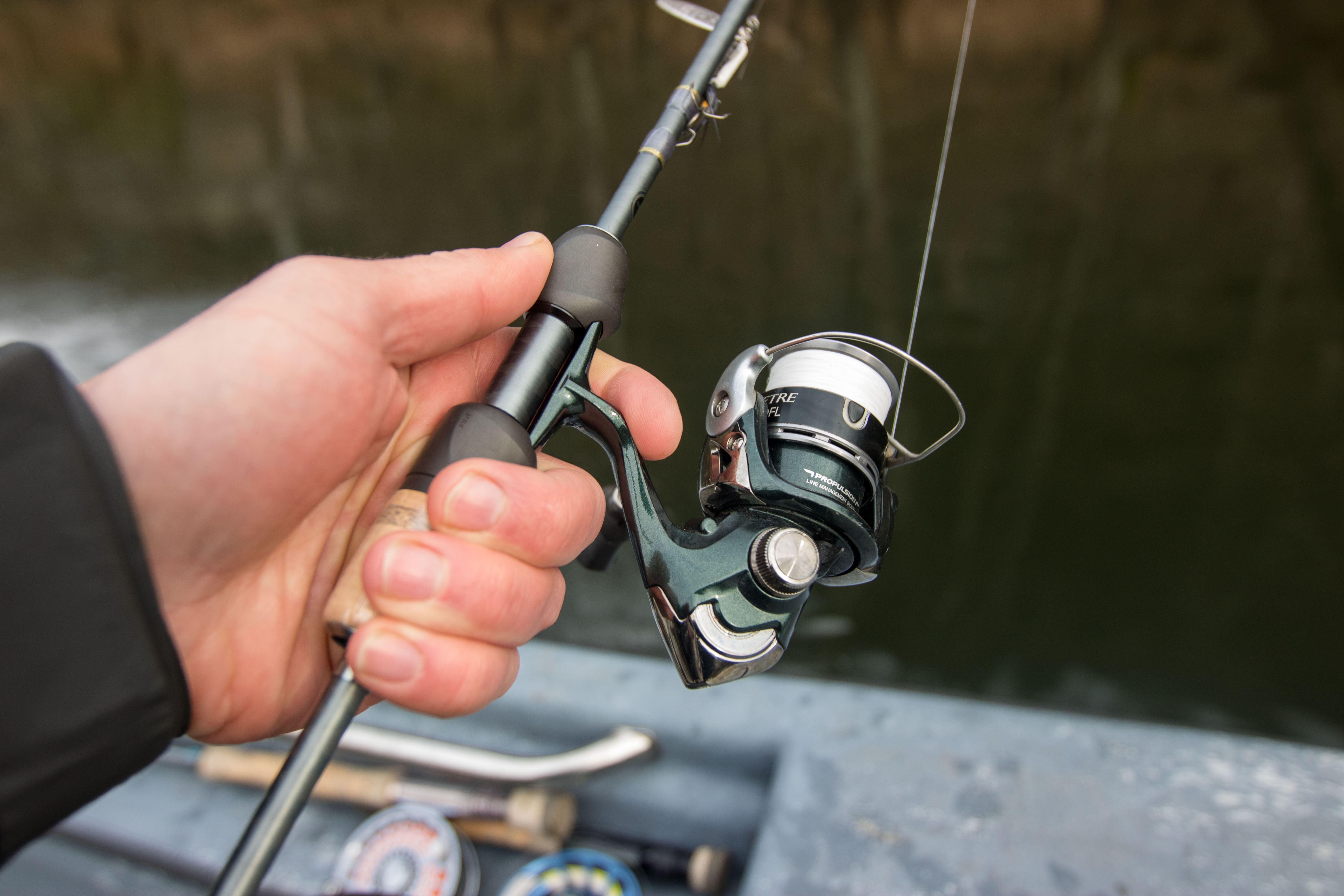 A rod handle in an anglers hand.