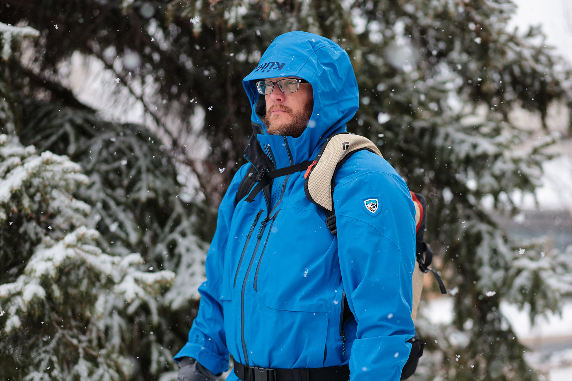 Front view of a person wearing the Dawn Patrol 25 pack in falling snow