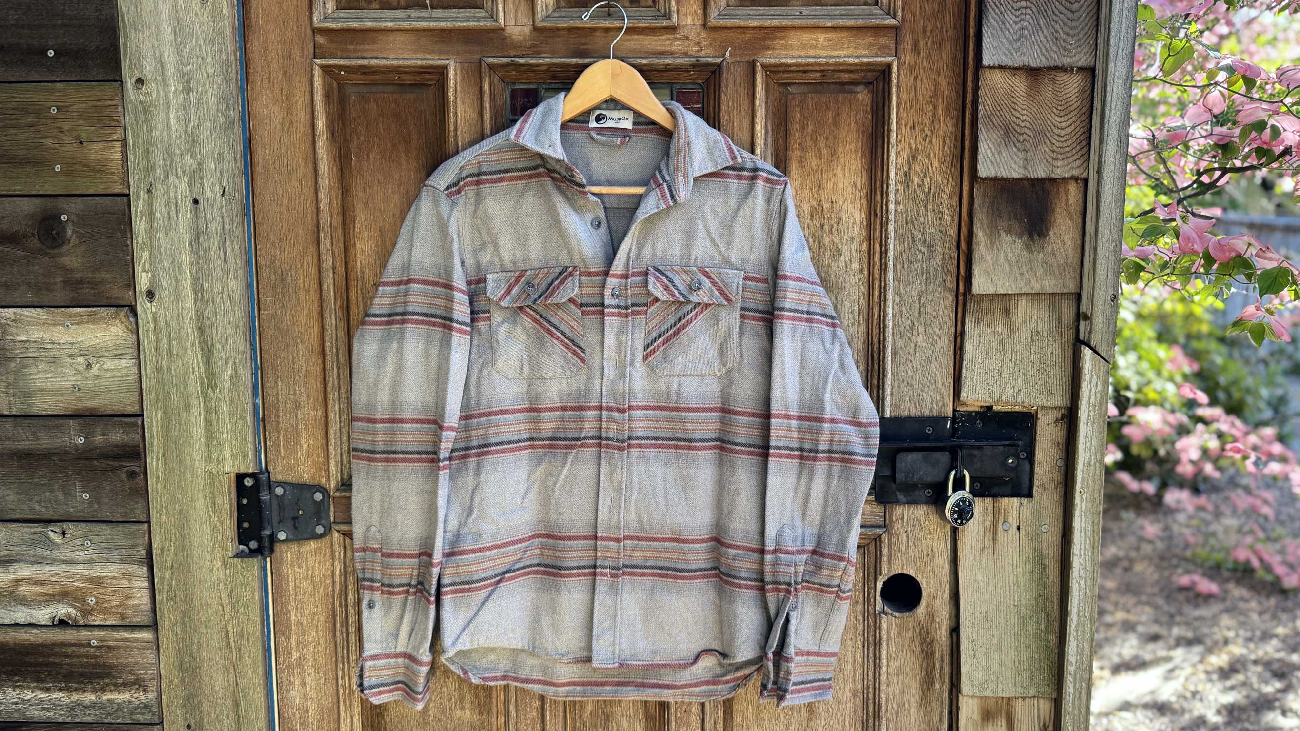 the field grand flannel hangs on a hanger outside a doorway