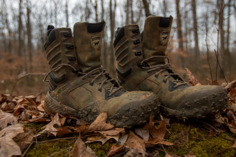 The Irish Setter Vaprtrek boots in front of a wooded landscape.