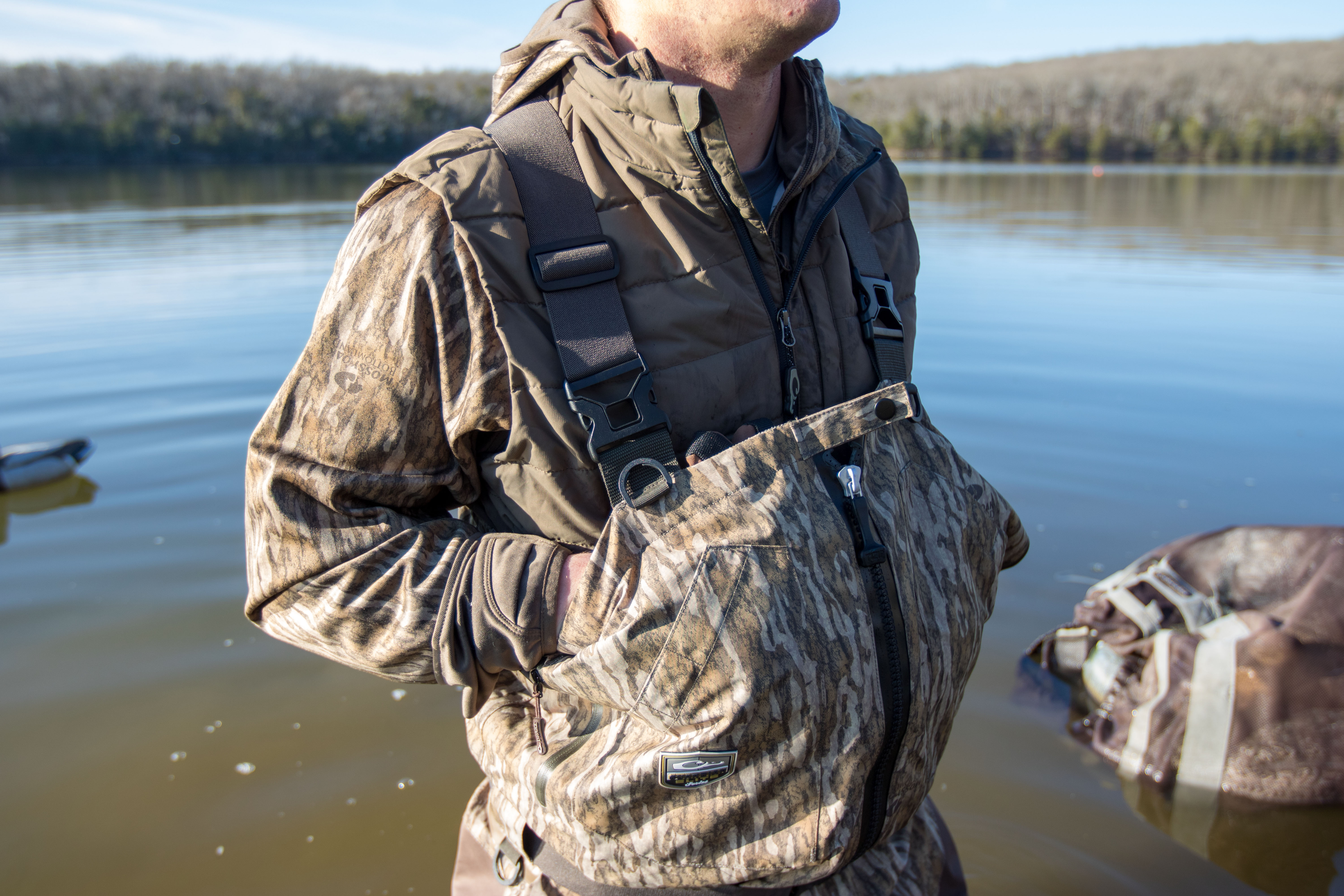 A hunter with his hands placed in the internal handwarming pockets of the Guardian Elite Zip Front Wader