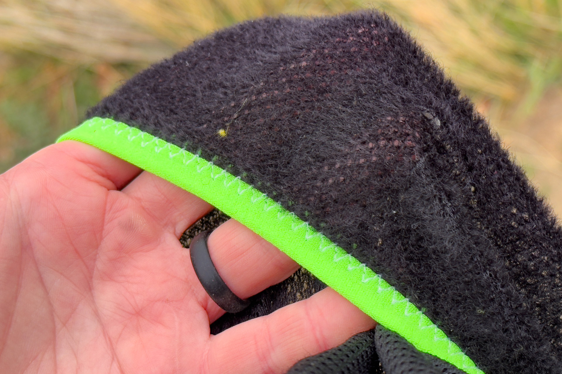 Teijin Octa fleece cuff shown in close-up, held by a hand with visible stitching and lining
