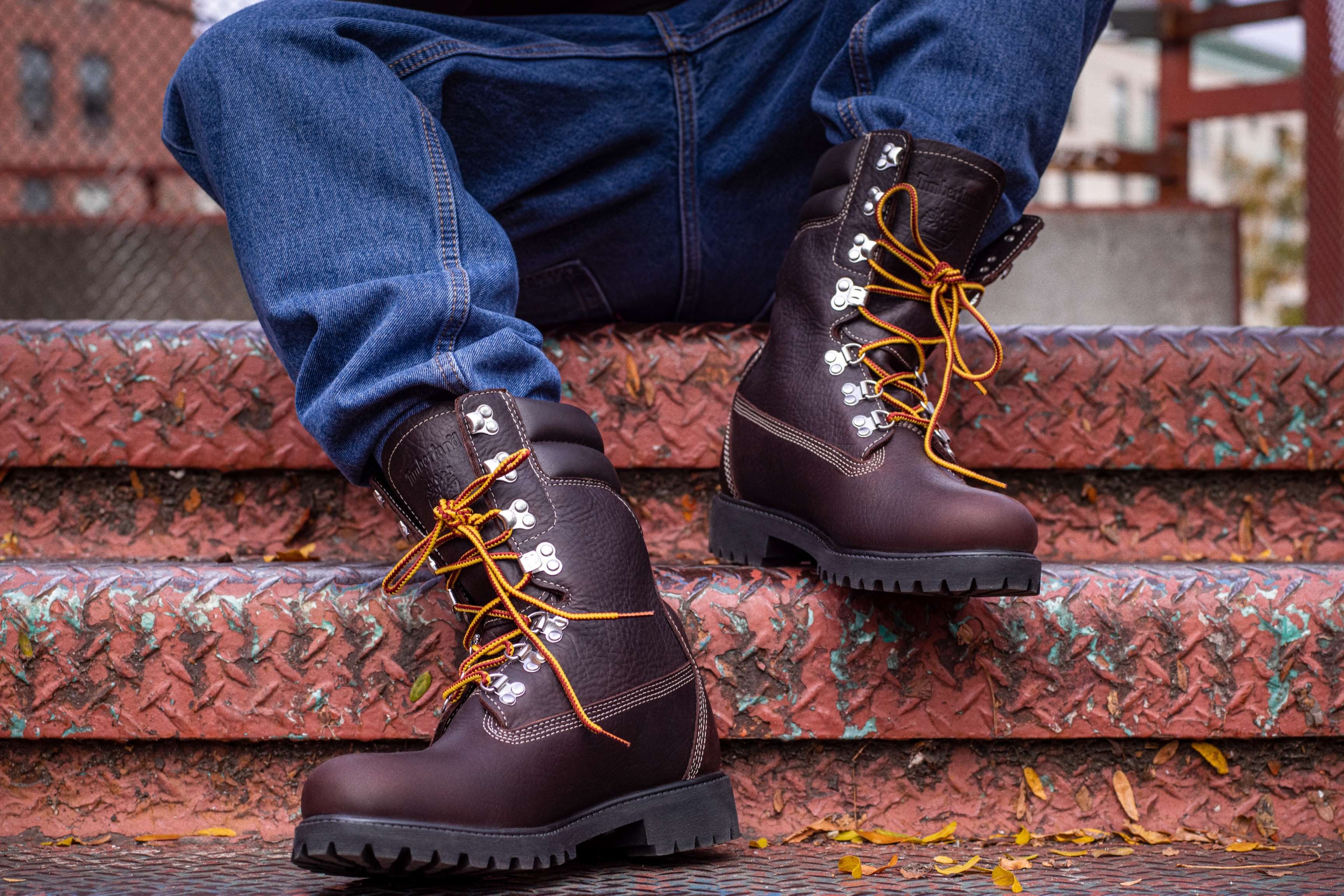 person sits on steps wearing boots