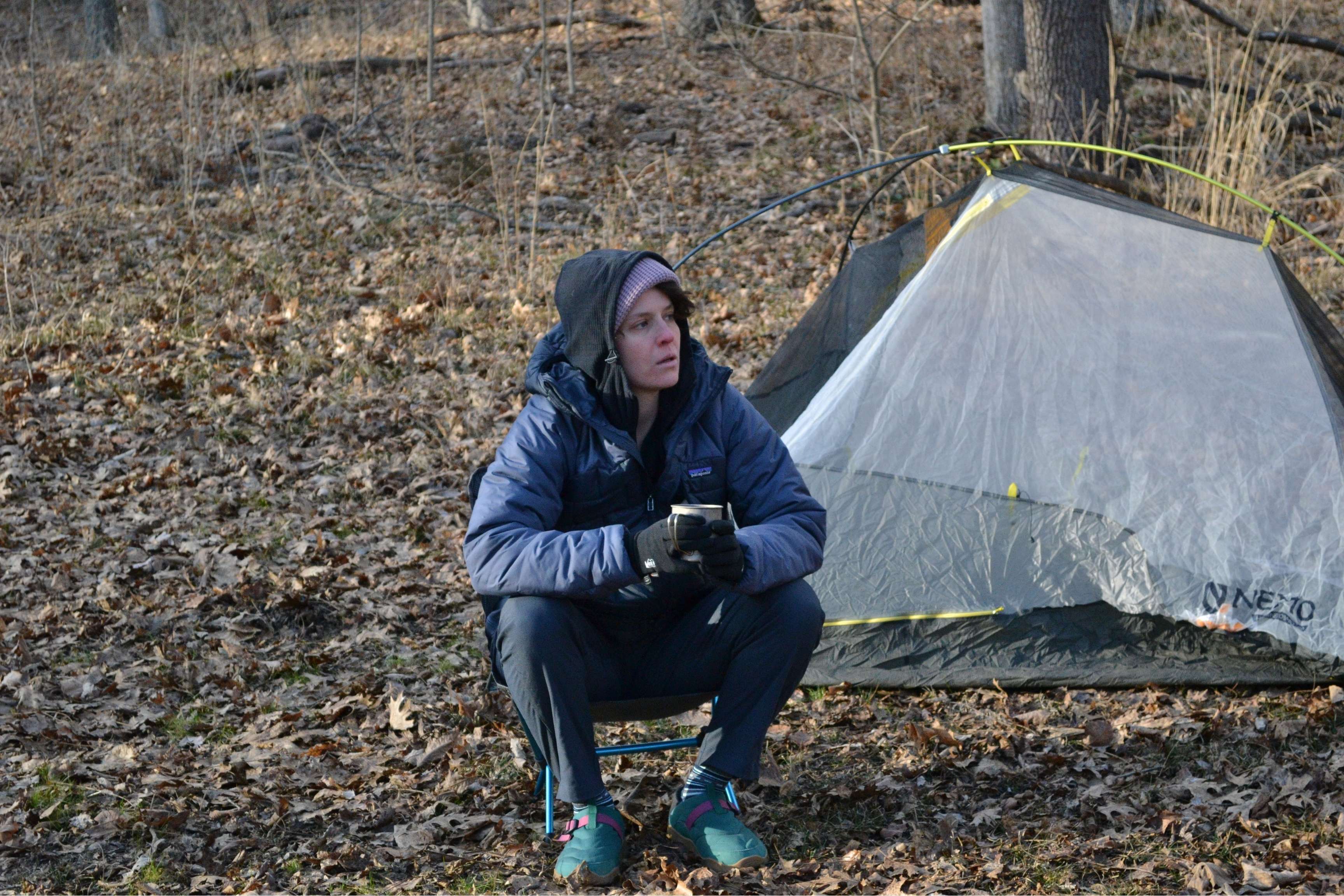 person sitting in chair by tent