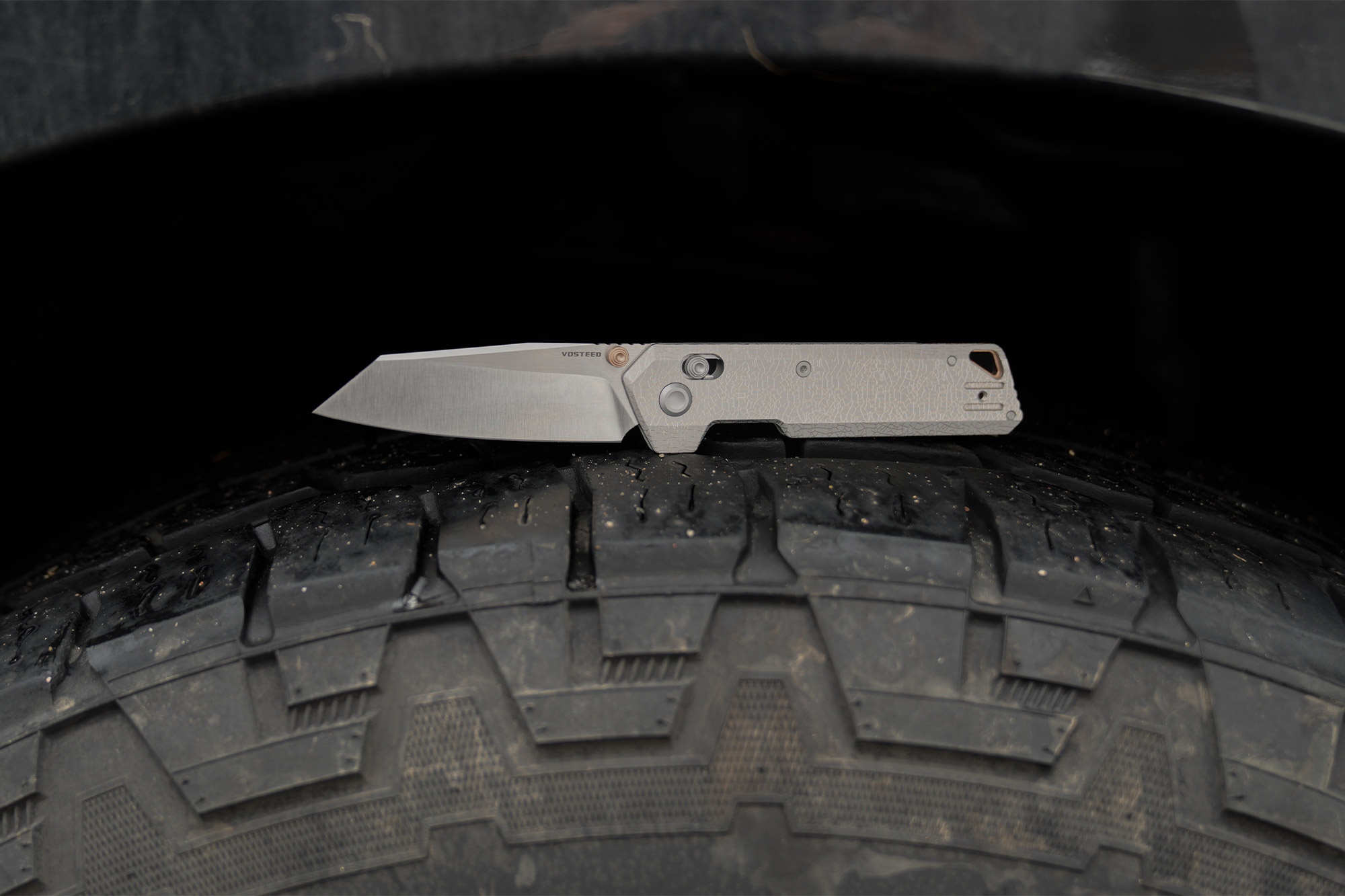 The Vosteed Parallel folding knife shown open in a side profile on a rugged surface