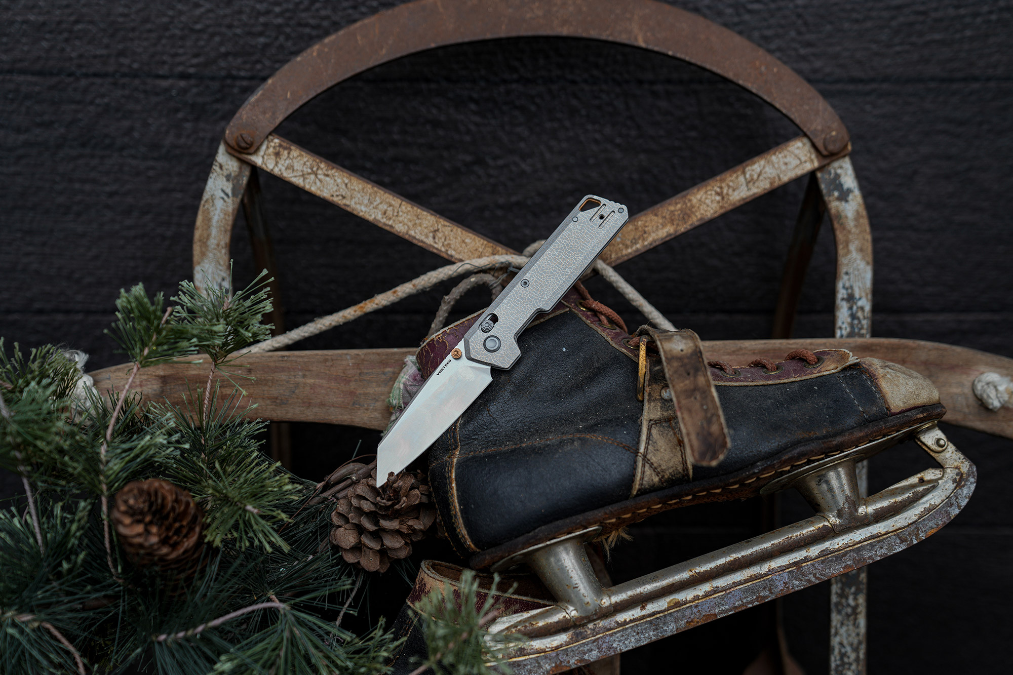 The Vosteed Parallel folding knife placed on a boot and sled in an outdoor setting