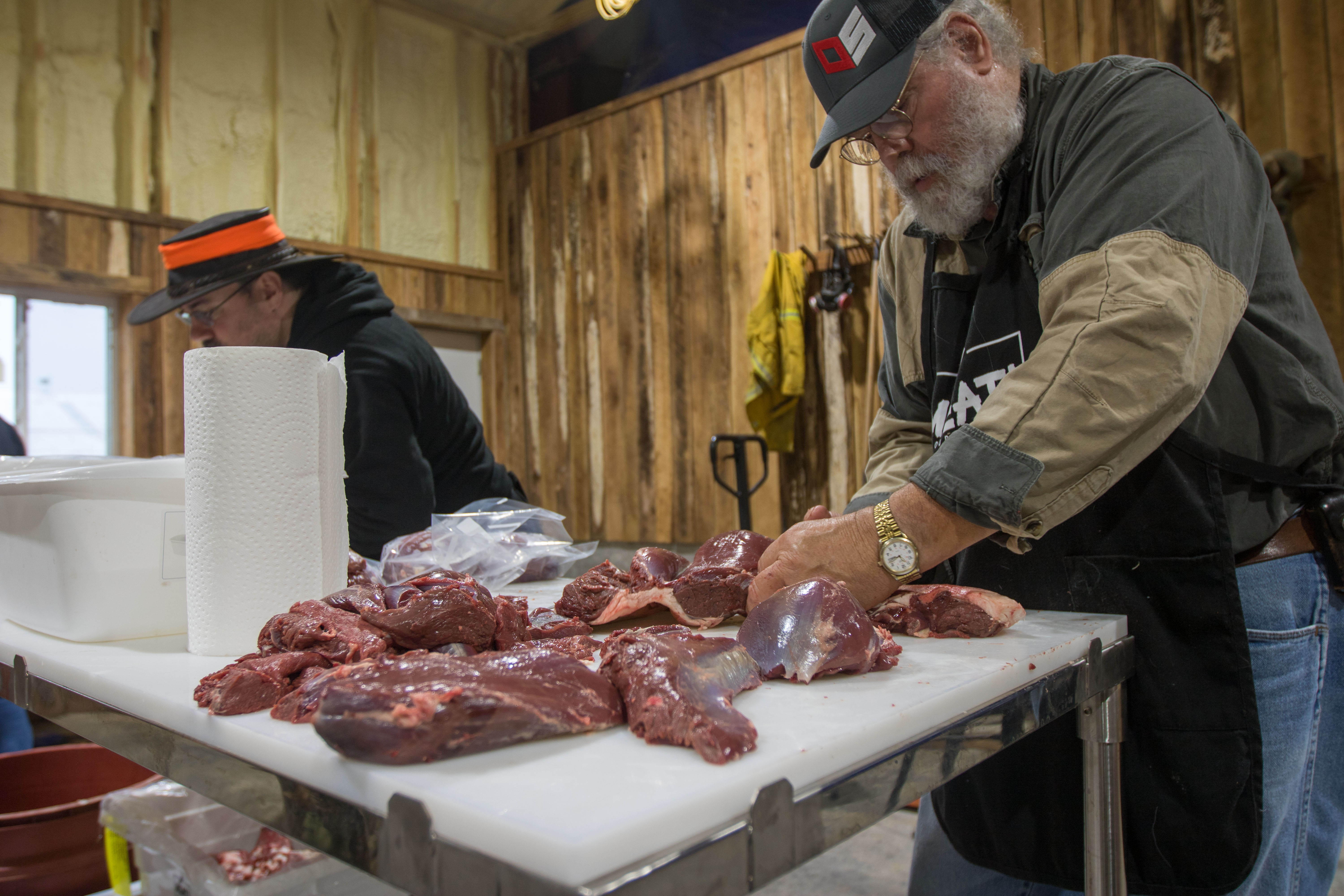 A man butchering a deer at a field to table experience with Outdoor Solutions.