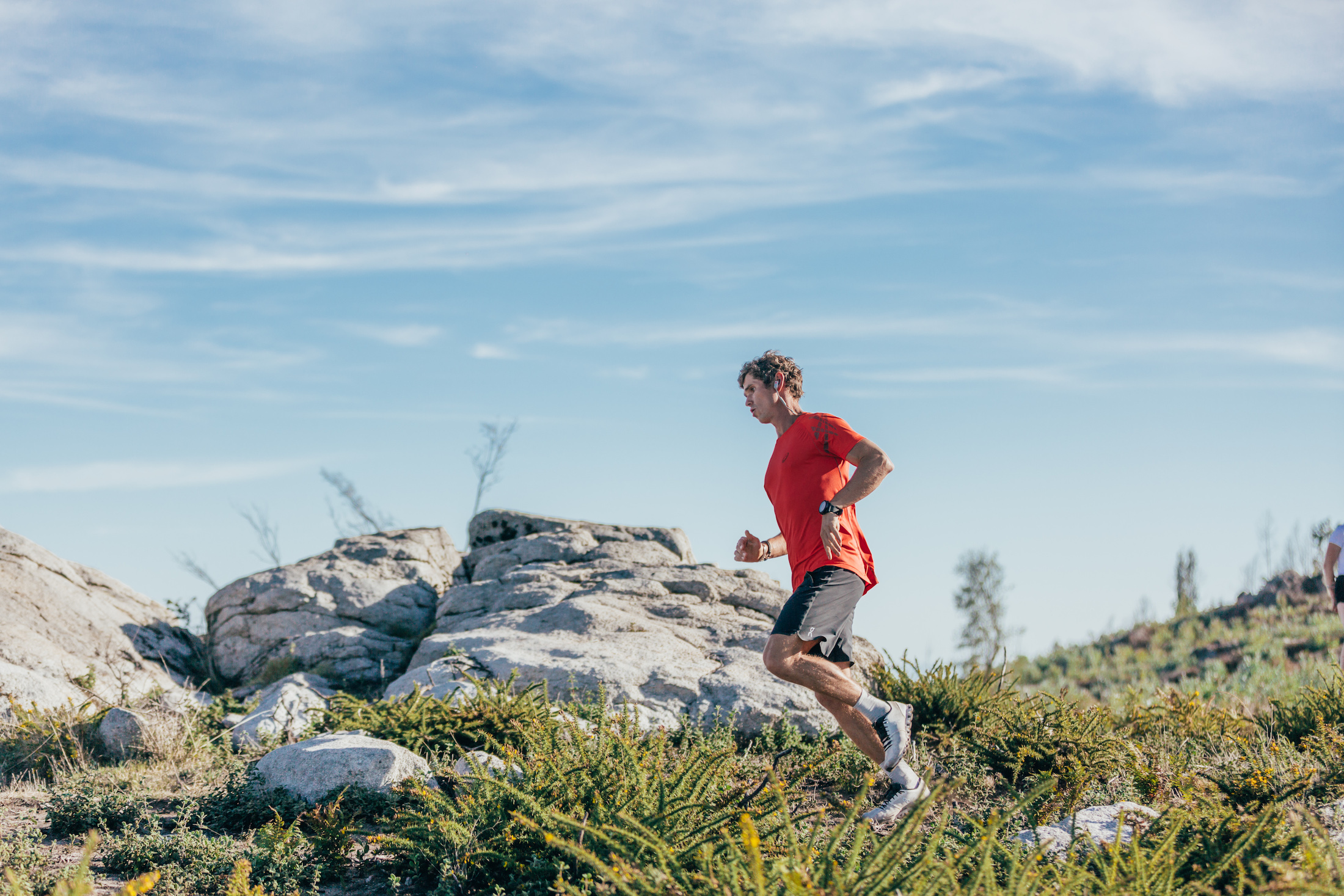 person trail running in Rockay socks with blue sky background