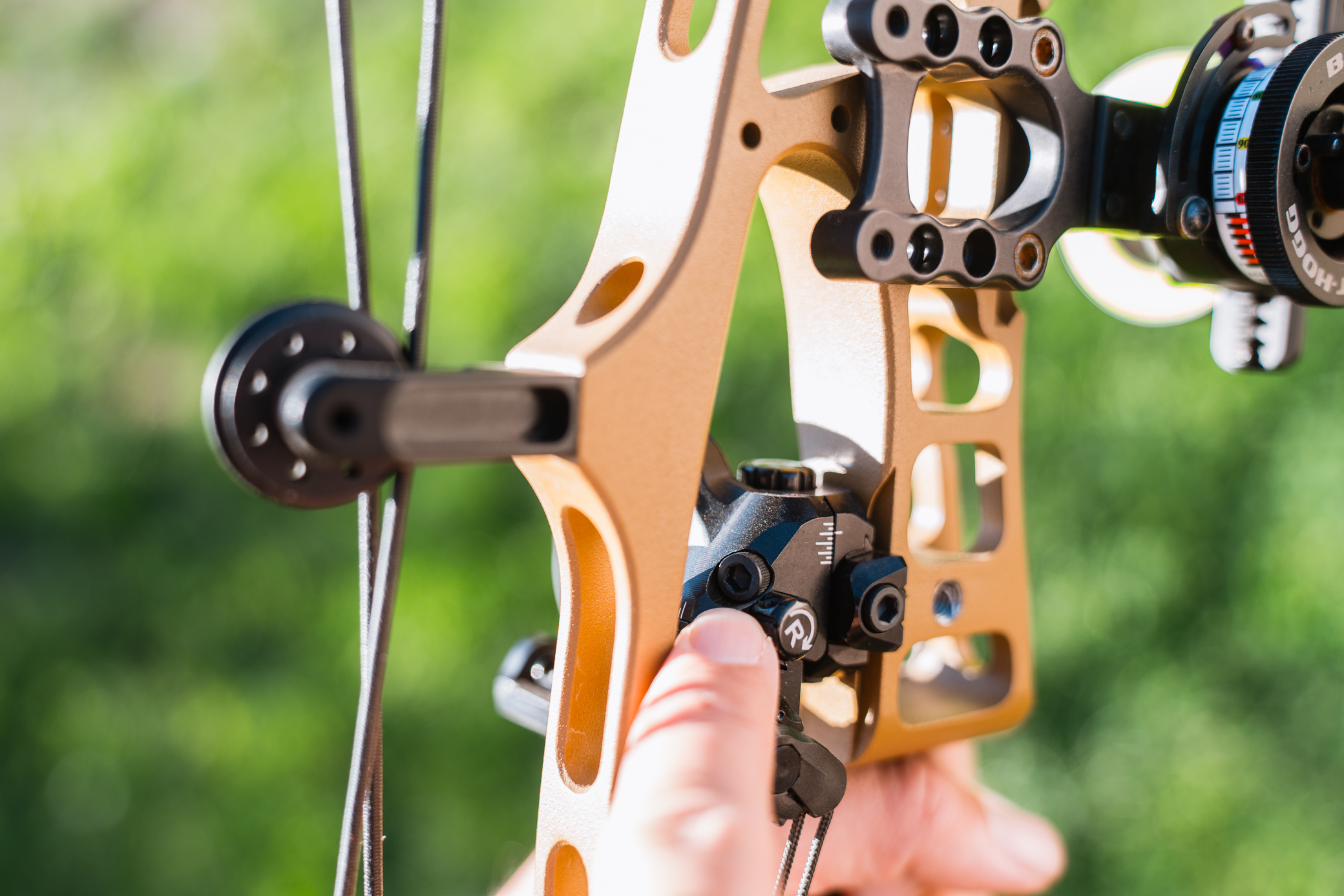 The Hamskea R7 Arrow Rest is shown mounted on a compound bow while adjustments are being made