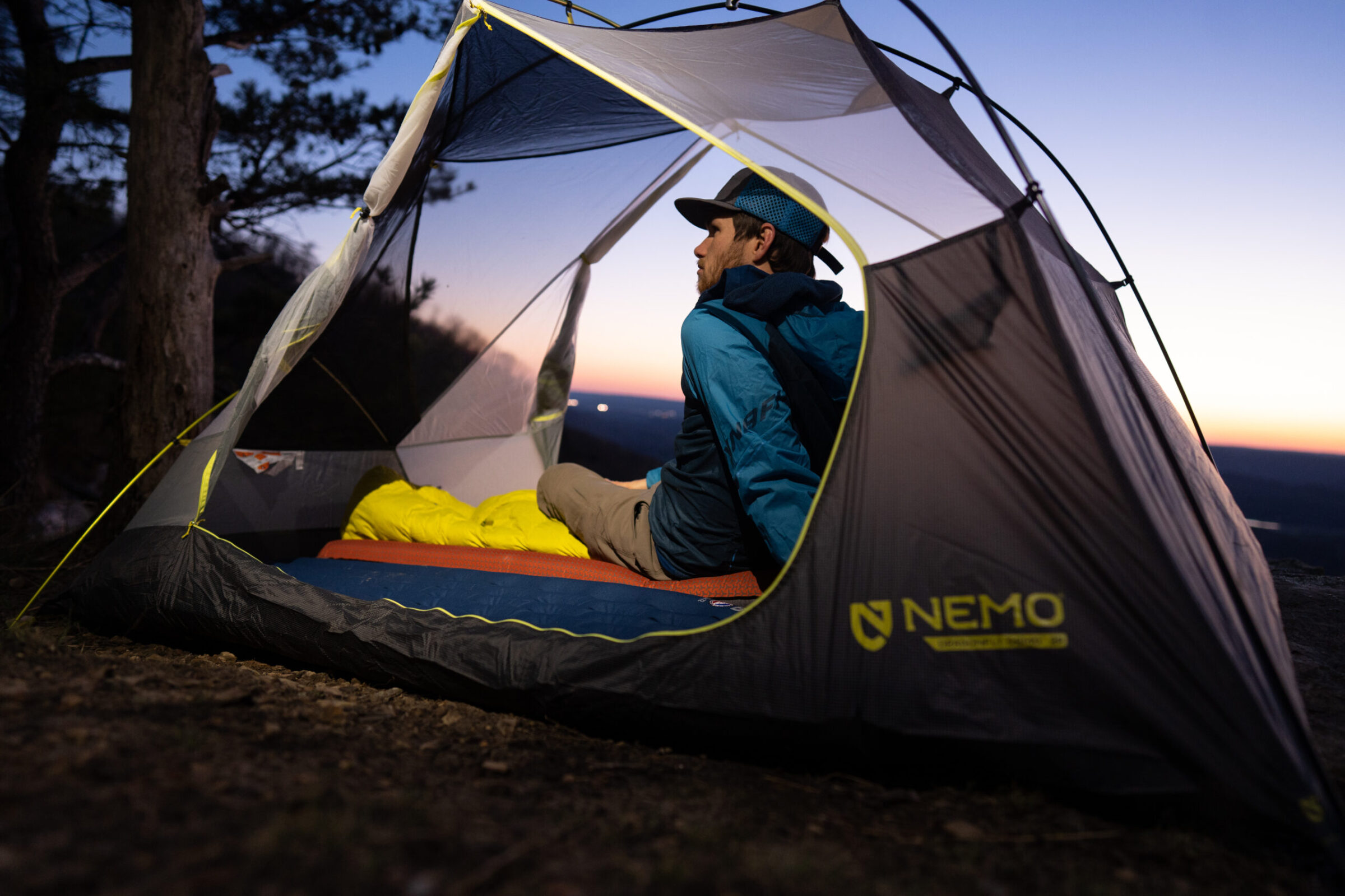 A man sits in a backpacking tent in the dark