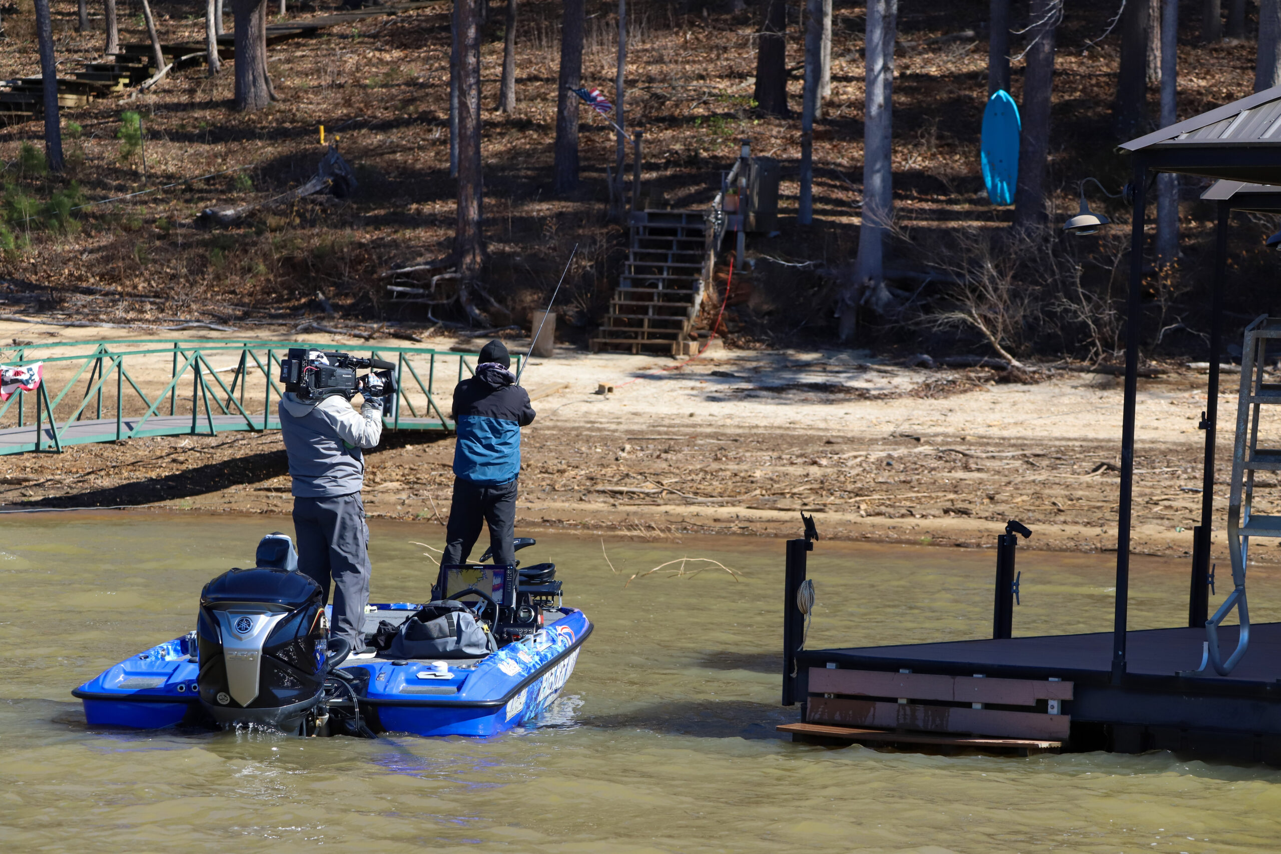 An angler on a bass boat fishing shallow water next to docks on dry ground at BPT Stop 2