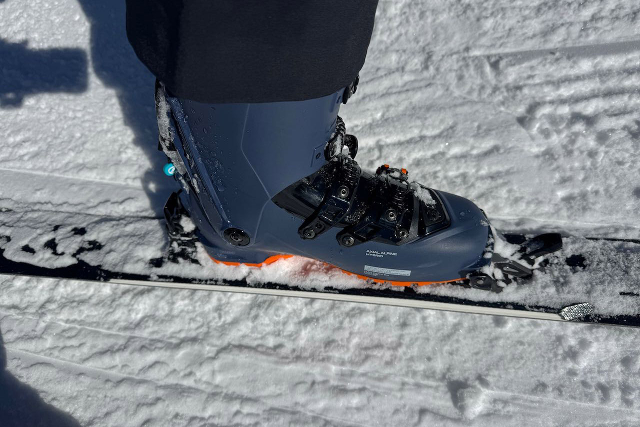 Close-up of ski boot clipped into binding on snow