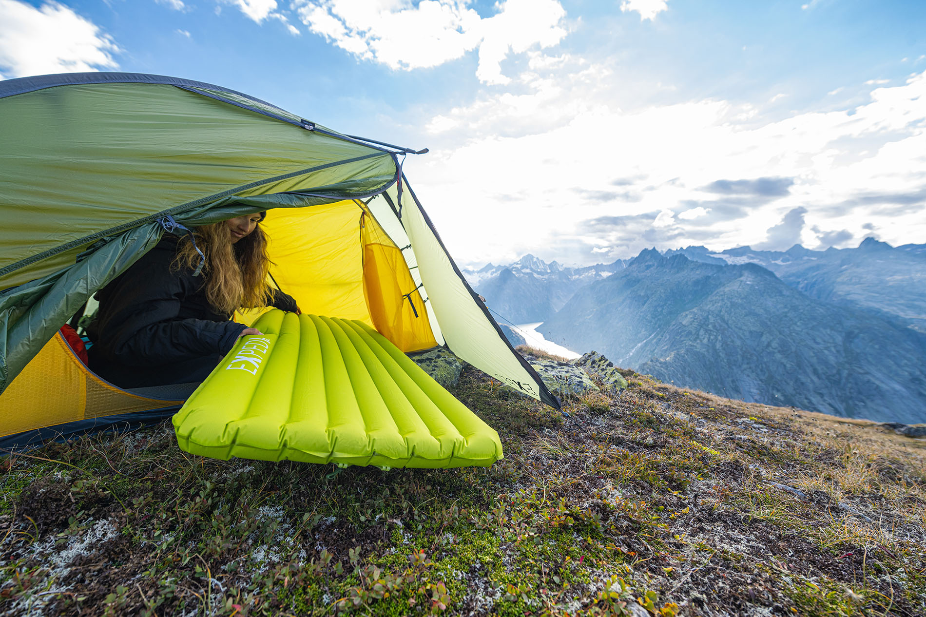 woman in tent holding exped ultra 6.5r sleeping pad