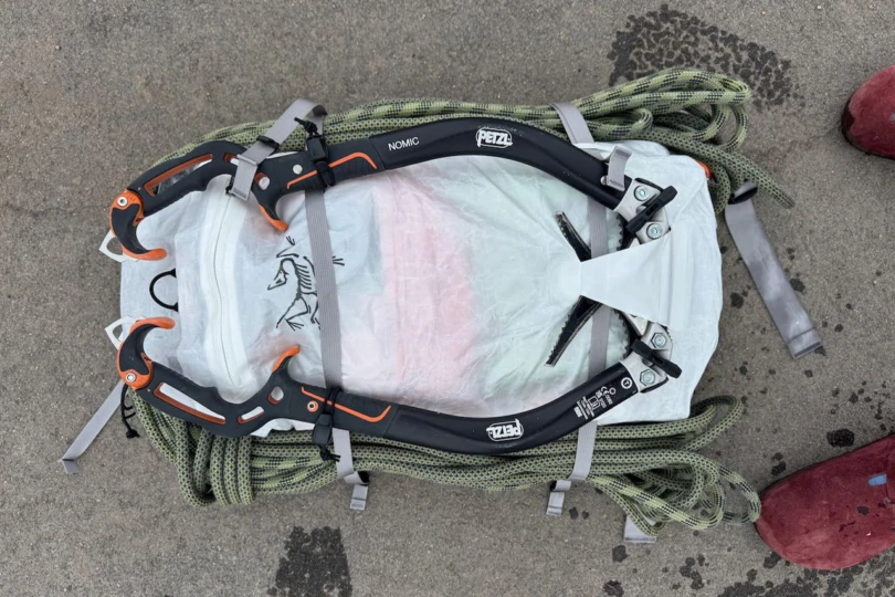 The Alpha SL climbing pack carrying ice tools and rope secured to the outside