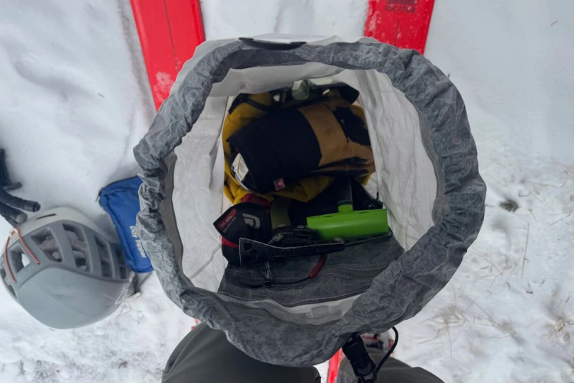 Inside the Arc’teryx Alpha SL backpack showing avalanche gear and small items packed for touring