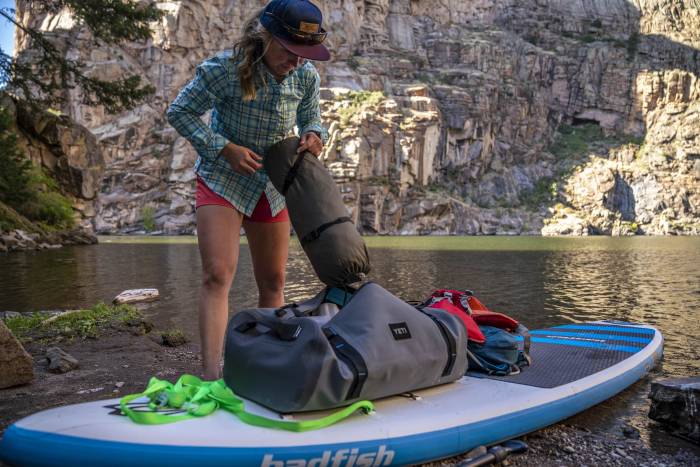 Morgan Tilton grabbing a tent on an overnight SUP trip